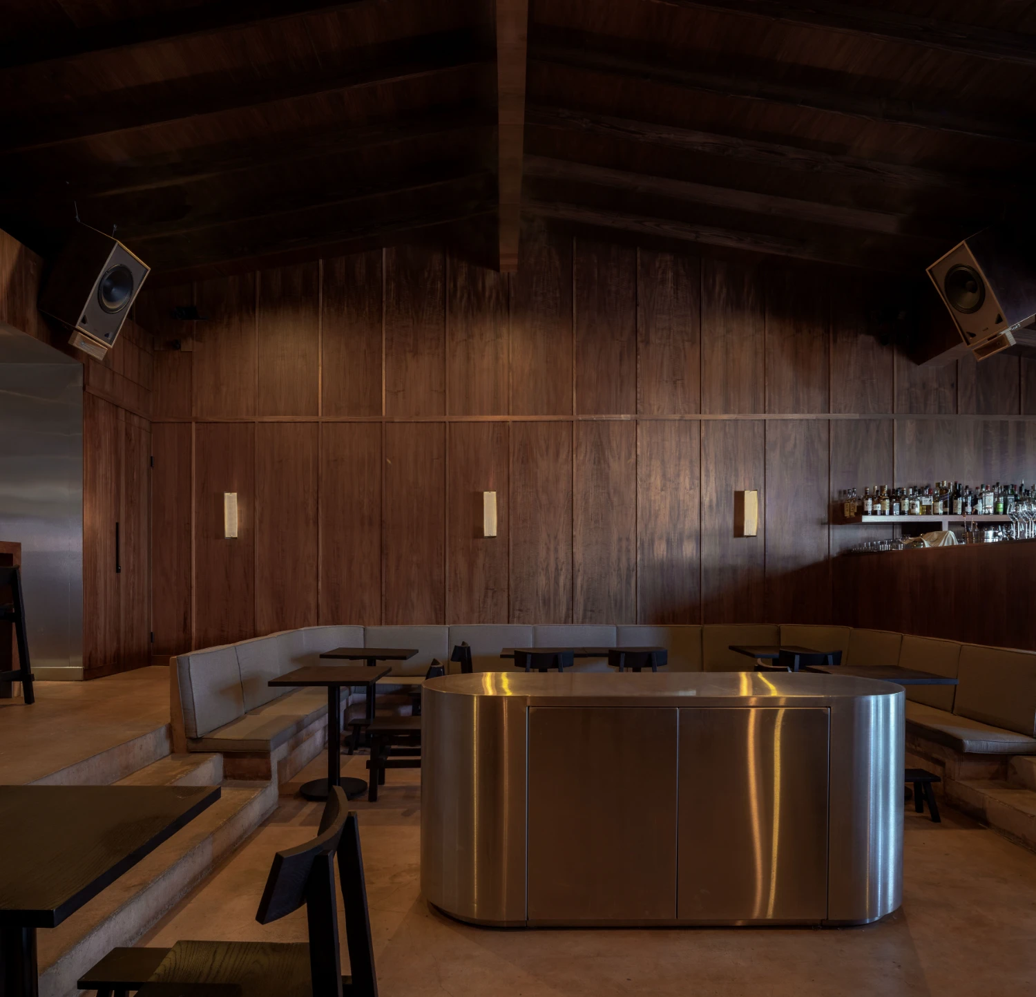 ZUKE Restaurant by Sofía Betancur + Taller Nacional — The brushed steel counter occupies the spatial center of ZUKE's dining room, its cylindrical form and reflective surface creating a focal point against the...
