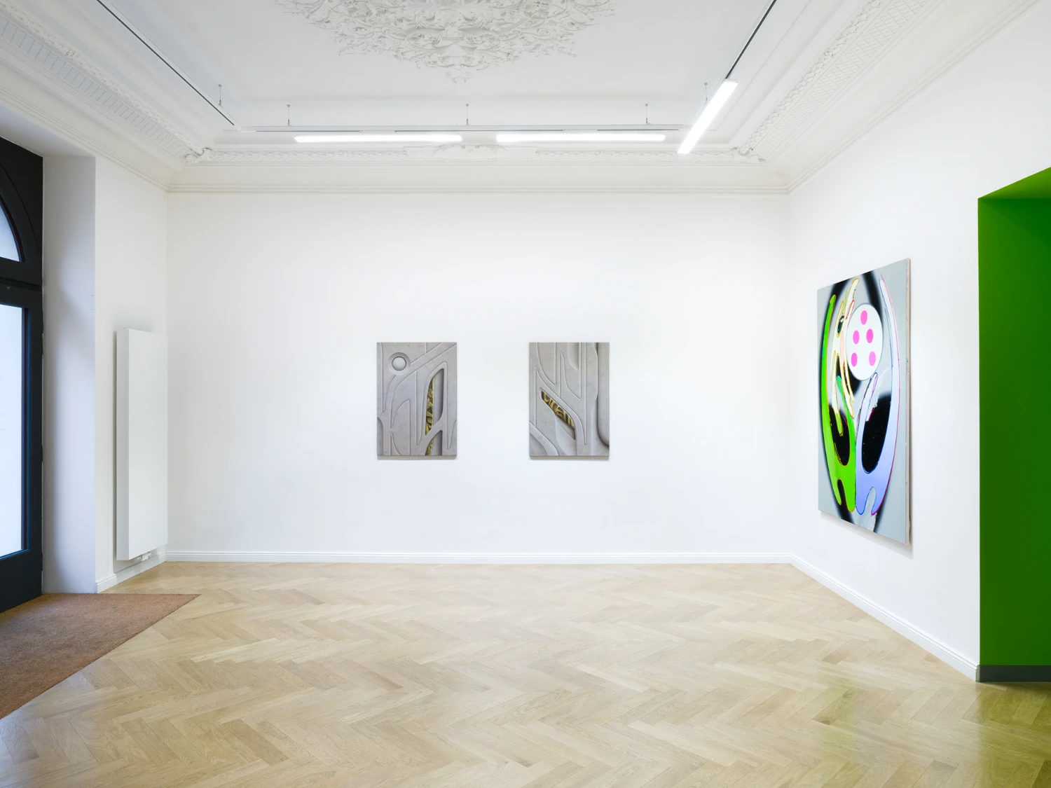 Bloom by Tomáš Absolon Milan Vagač at SPOT Gallery — The gallery's main wall presents a tripartite composition: two modest gray-toned relief panels occupy the center, their textured surfaces catching overhead...