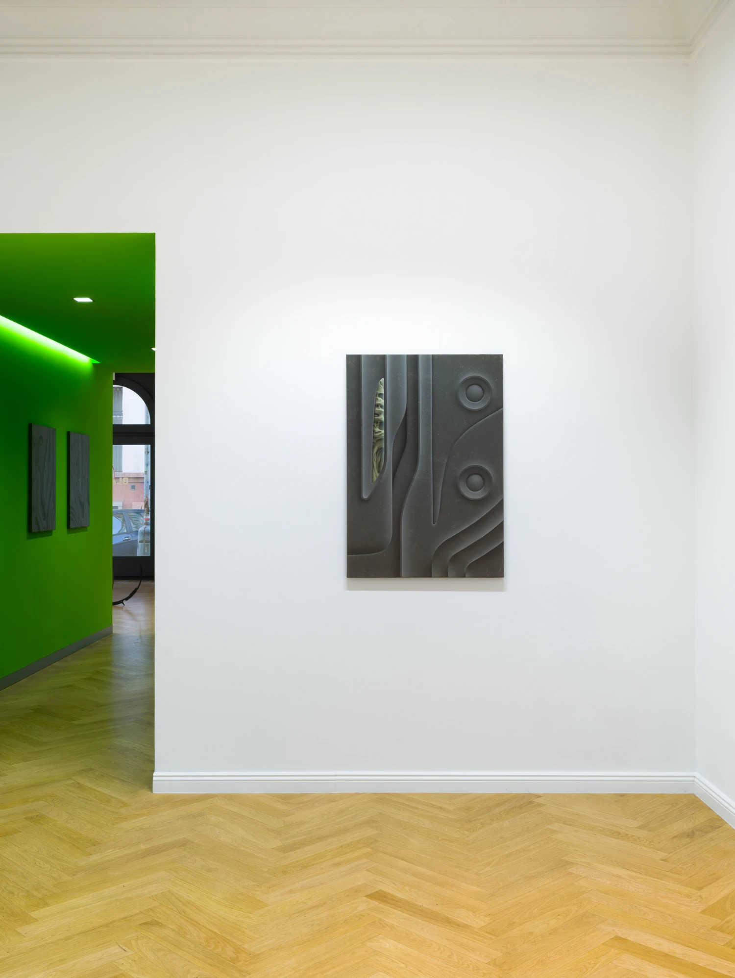 Bloom by Tomáš Absolon Milan Vagač at SPOT Gallery — A relief panel mounted on white plaster wall, centered in the gallery's right-hand room.