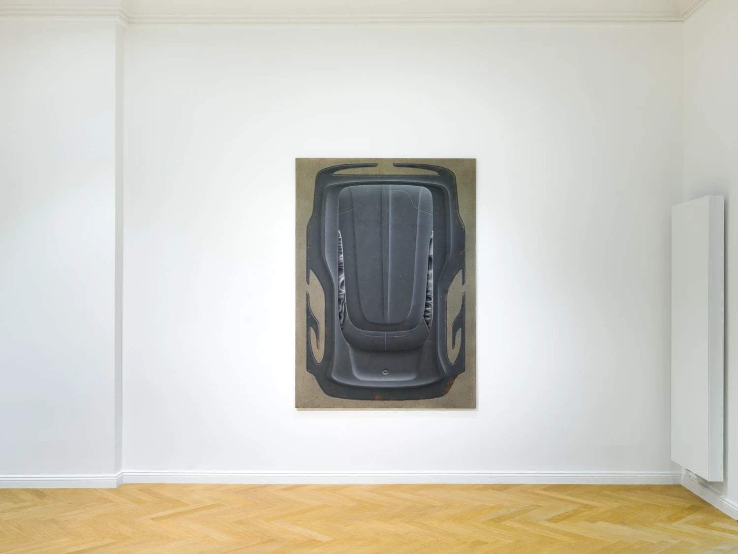 Bloom by Tomáš Absolon Milan Vagač at SPOT Gallery — A dark automotive form dominates the gallery wall in overhead perspective, rendered in charcoal and graphite against a beige ground.