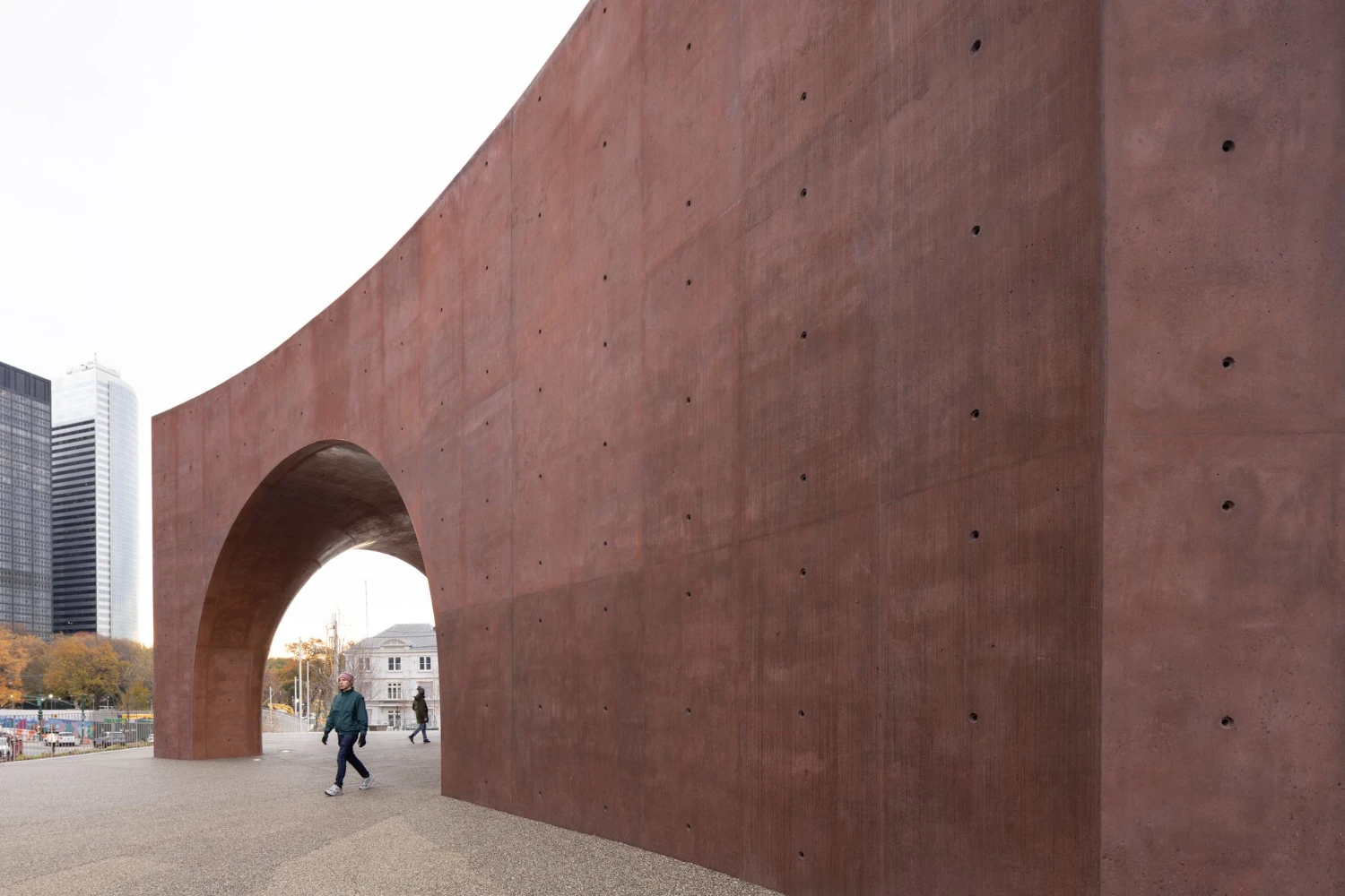 Wagner Park Pavilion by Thomas Phifer — A monumental concrete gateway anchors the Wagner Park Pavilion's entrance, its twin curved archways framing a view toward the harbor beyond.