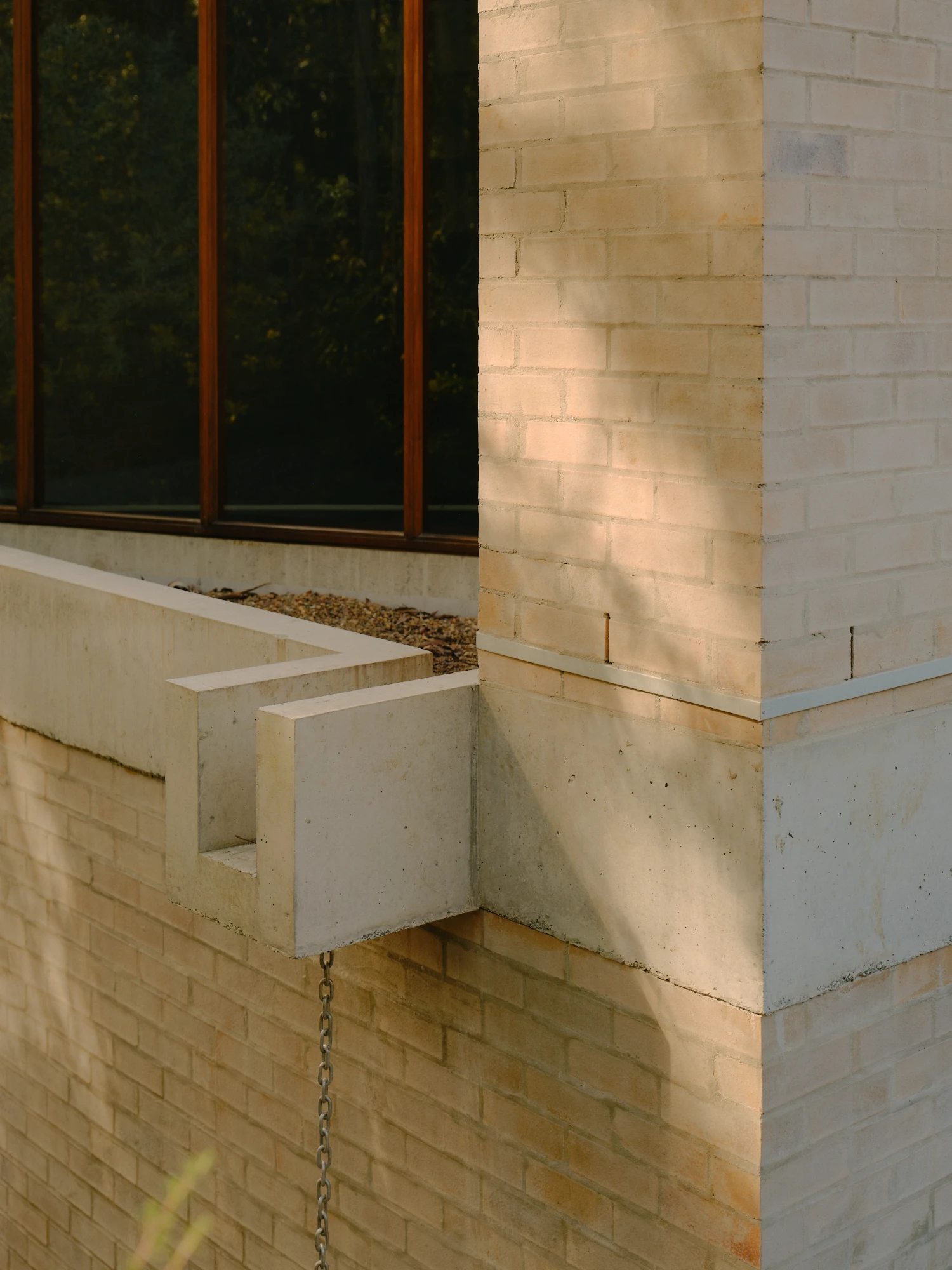 Stuartholme House by Nielsen Jenkins + Michael Lumby — The photograph captures a corner detail of Stuartholme House, isolating the junction between brick wall and precast concrete structural elements.