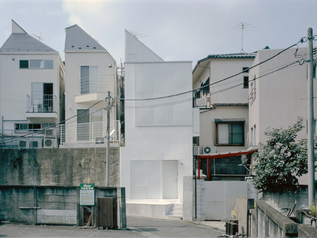 Long Tall House by Spacespace — Spacespace's Long Tall House presents its compressed five-storey facade to the street, a stark white rendered surface wedged between neighboring structures...