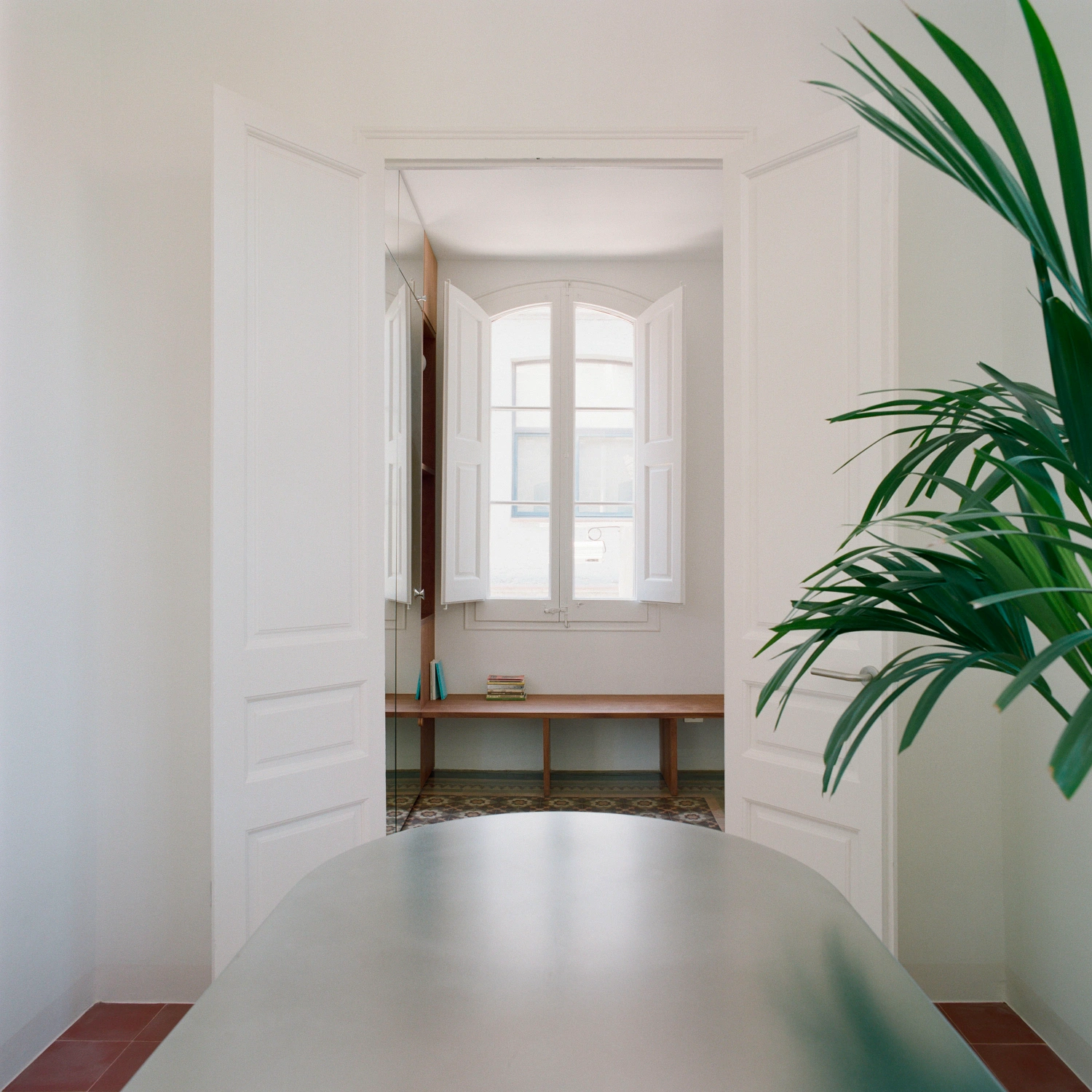 LL731 by Aramé Studio — A threshold view into a fluid domestic interior where circulation and materiality define space.