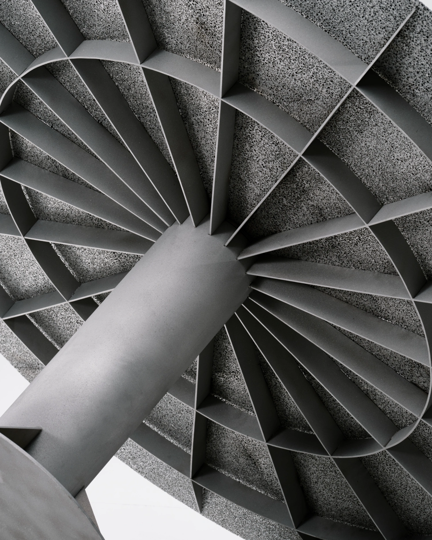 M.I.G. Store by AVOIR — Overhead view of a spiraling ventilation duct or architectural element centered within a radial arrangement of triangular concrete sections.