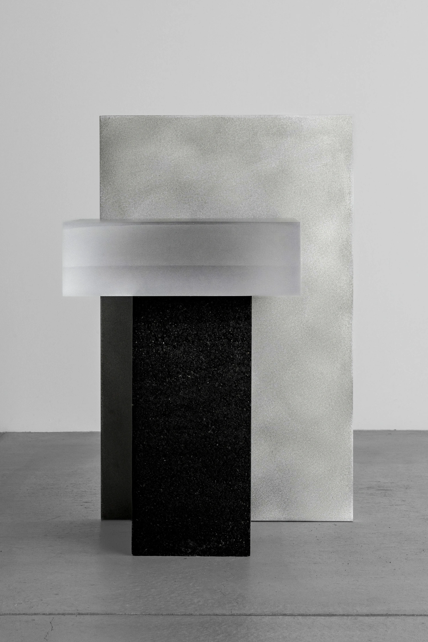 As by So Koizumi — A sculptural assembly of stacked stone and asphalt blocks arranged on polished concrete flooring.