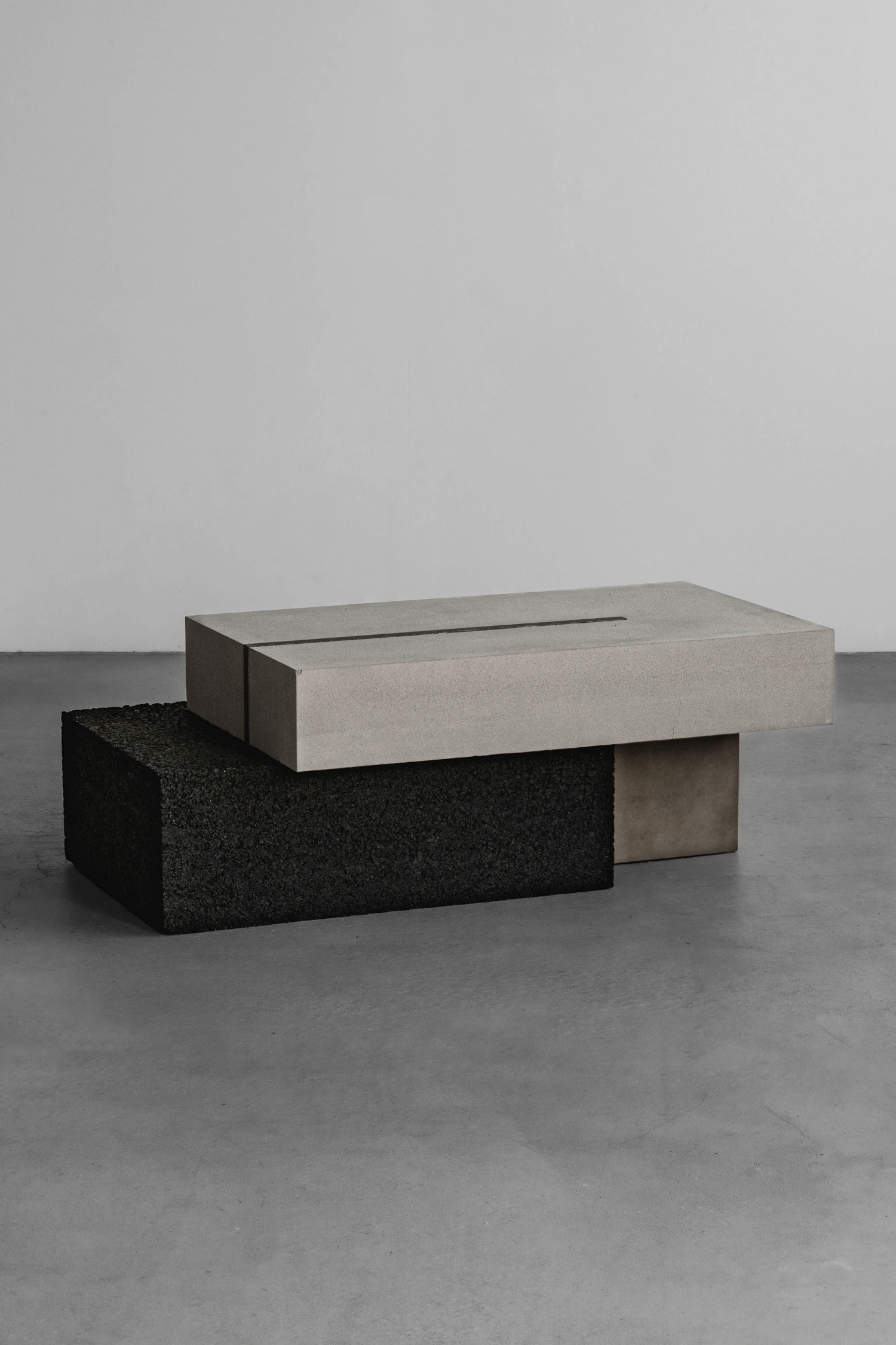 As by So Koizumi — Two stacked sculptural objects occupy the polished concrete floor in spatial separation.