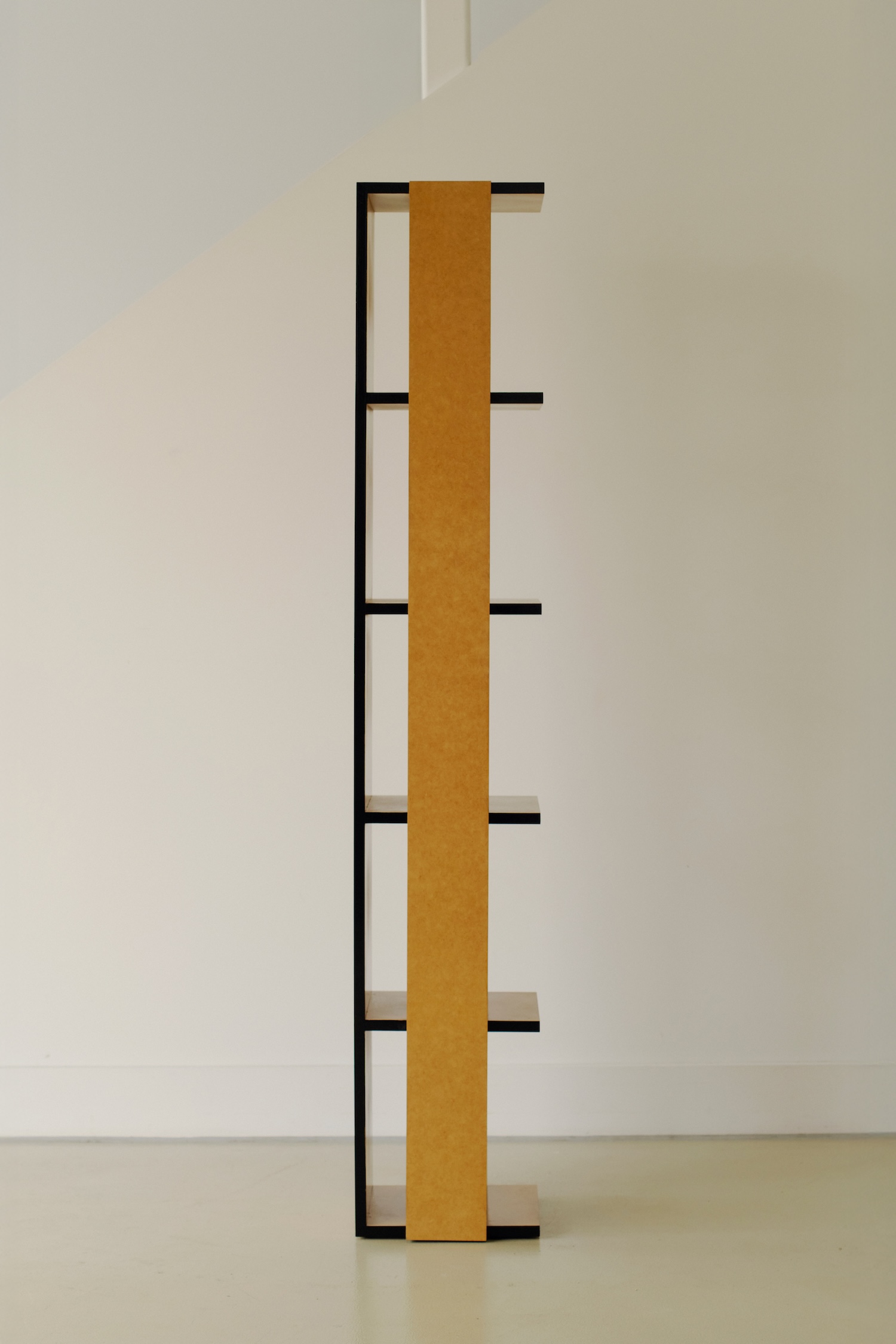 Undressed Collection by Georgina Davies — A tall vertical shelving unit from Davies's Undressed Collection presents five horizontal black steel shelves cantilevered from a continuous MDF backing...