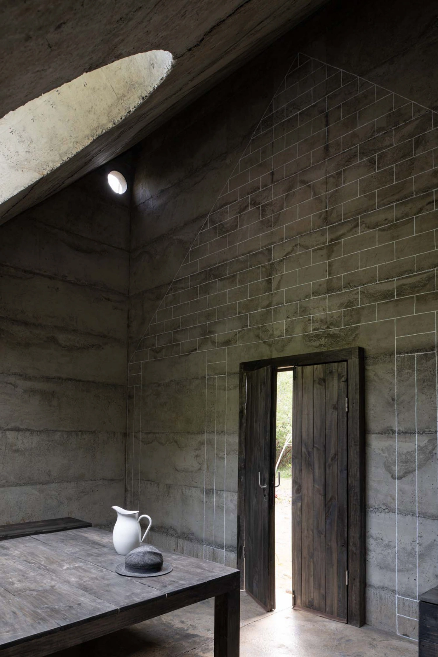 MIEL Pavilion by Pezo von Ellrichshausen — The MIEL Pavilion's interior reveals its asymmetric sectional strategy through a single photograph: a monolithic concrete shell rises to meet a large...