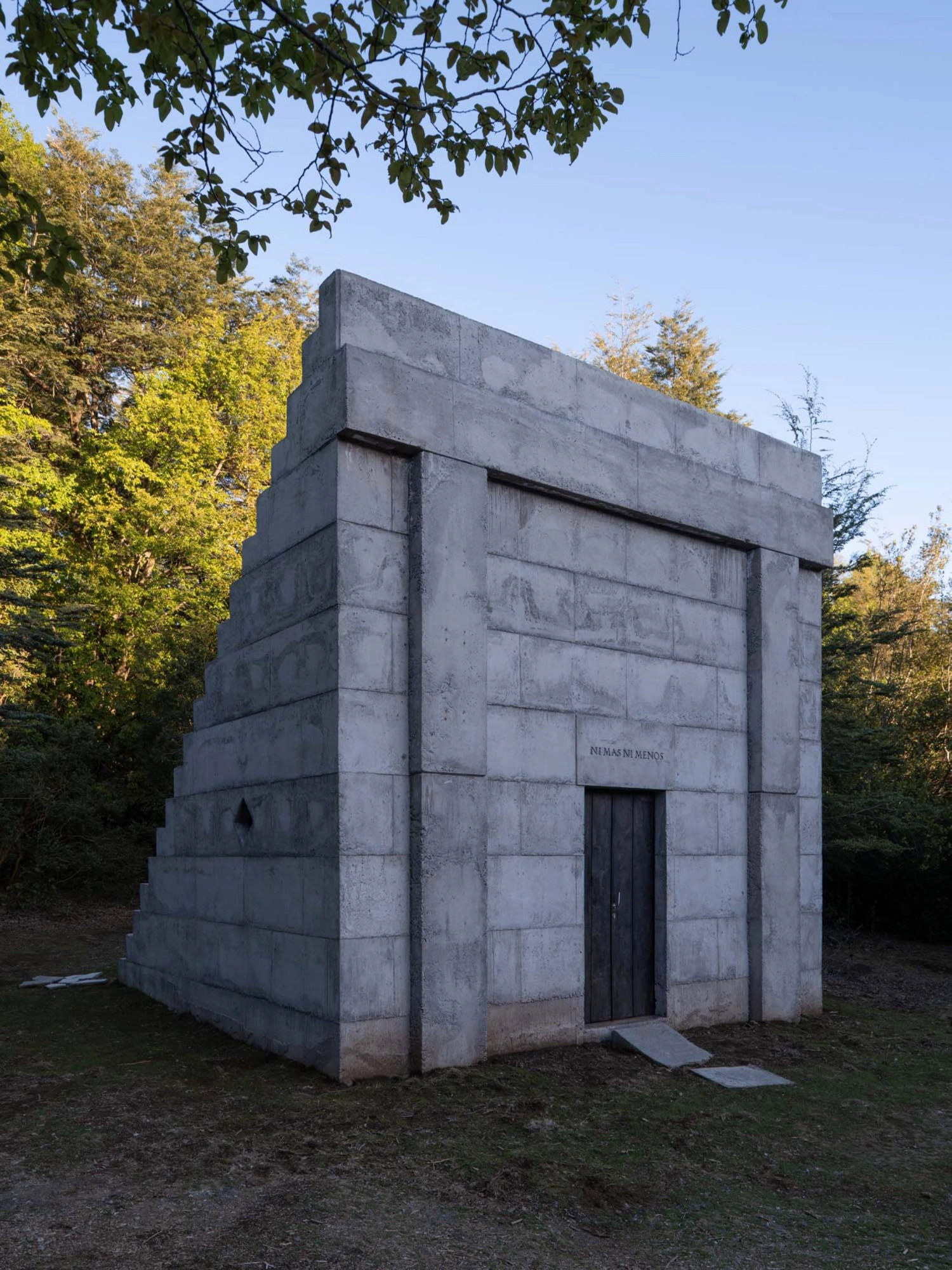 MIEL Pavilion by Pezo von Ellrichshausen — The MIEL Pavilion presents its monolithic concrete mass against autumn foliage, a rectilinear volume constructed from board-formed concrete.