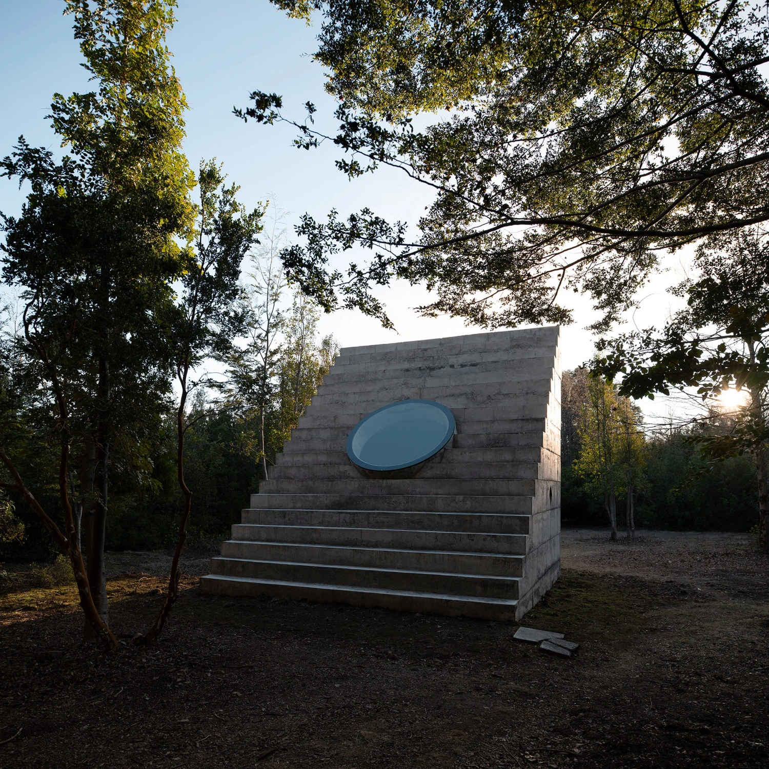MIEL Pavilion by Pezo von Ellrichshausen — The MIEL Pavilion presents itself as a monolithic concrete volume anchored within a dense forest clearing, its mass defined by a single commanding gesture:...