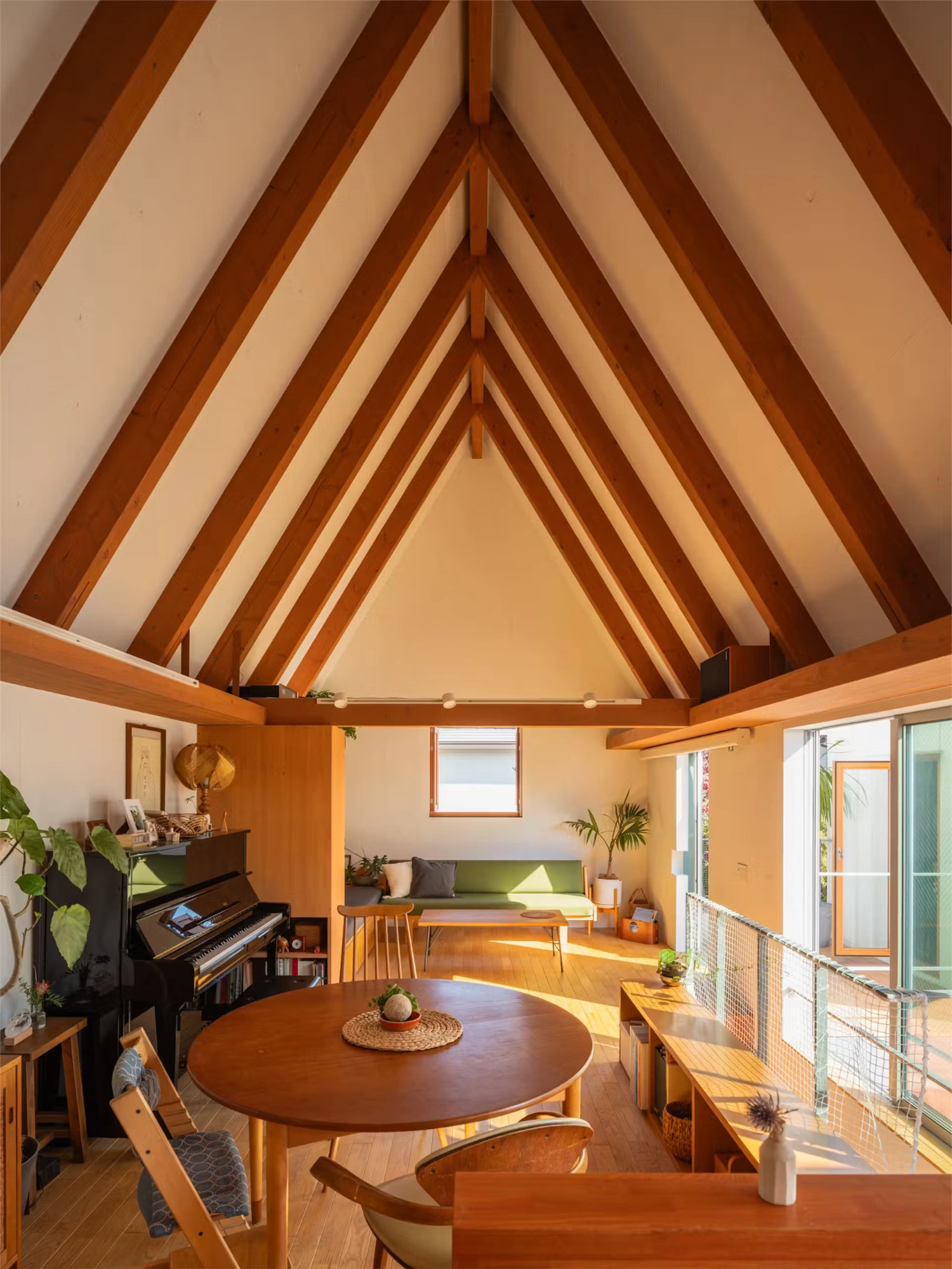 Little Village by Takeshi Hosaka — Interior view of a pitched-roof pavilion defined by exposed timber beams creating a rhythmic converging pattern toward the apex.