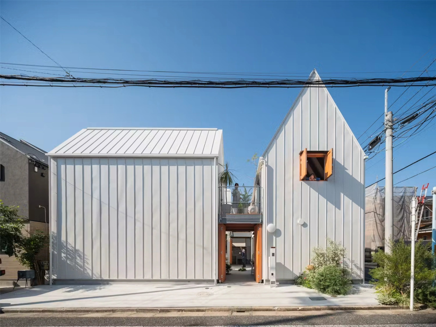 Little Village by Takeshi Hosaka — Little Village presents four discrete architectural volumes unified by corrugated metal cladding with vertical ribbing in white.