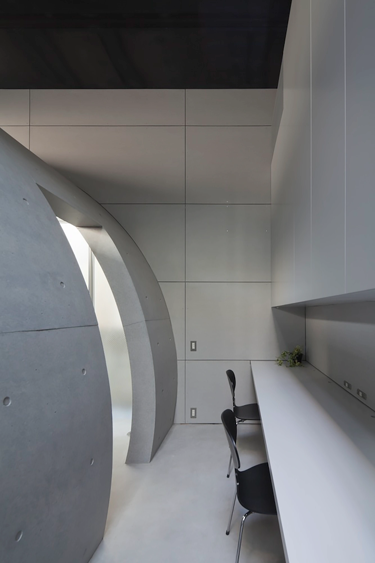 Tunnel House by Makiko Tsukada Architects — Interior view of the Tunnel House threshold, showing the quarter-cylinder void carved through the facade.