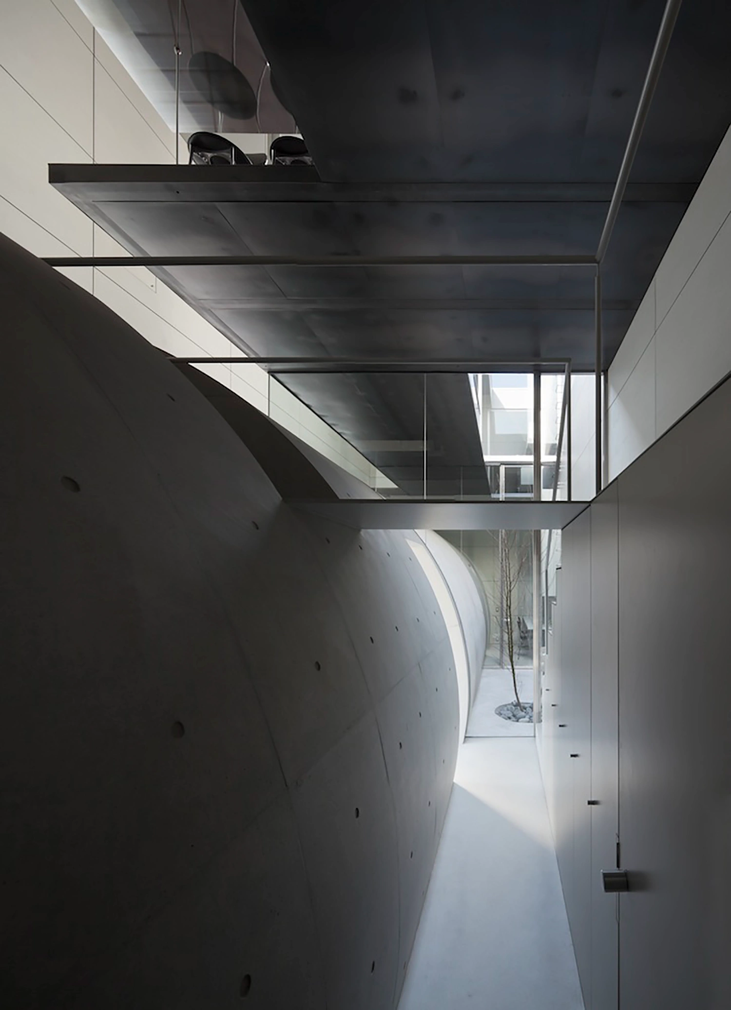Tunnel House by Makiko Tsukada Architects — A narrow passage reveals the quarter-cylinder void that defines the Tunnel House interior.