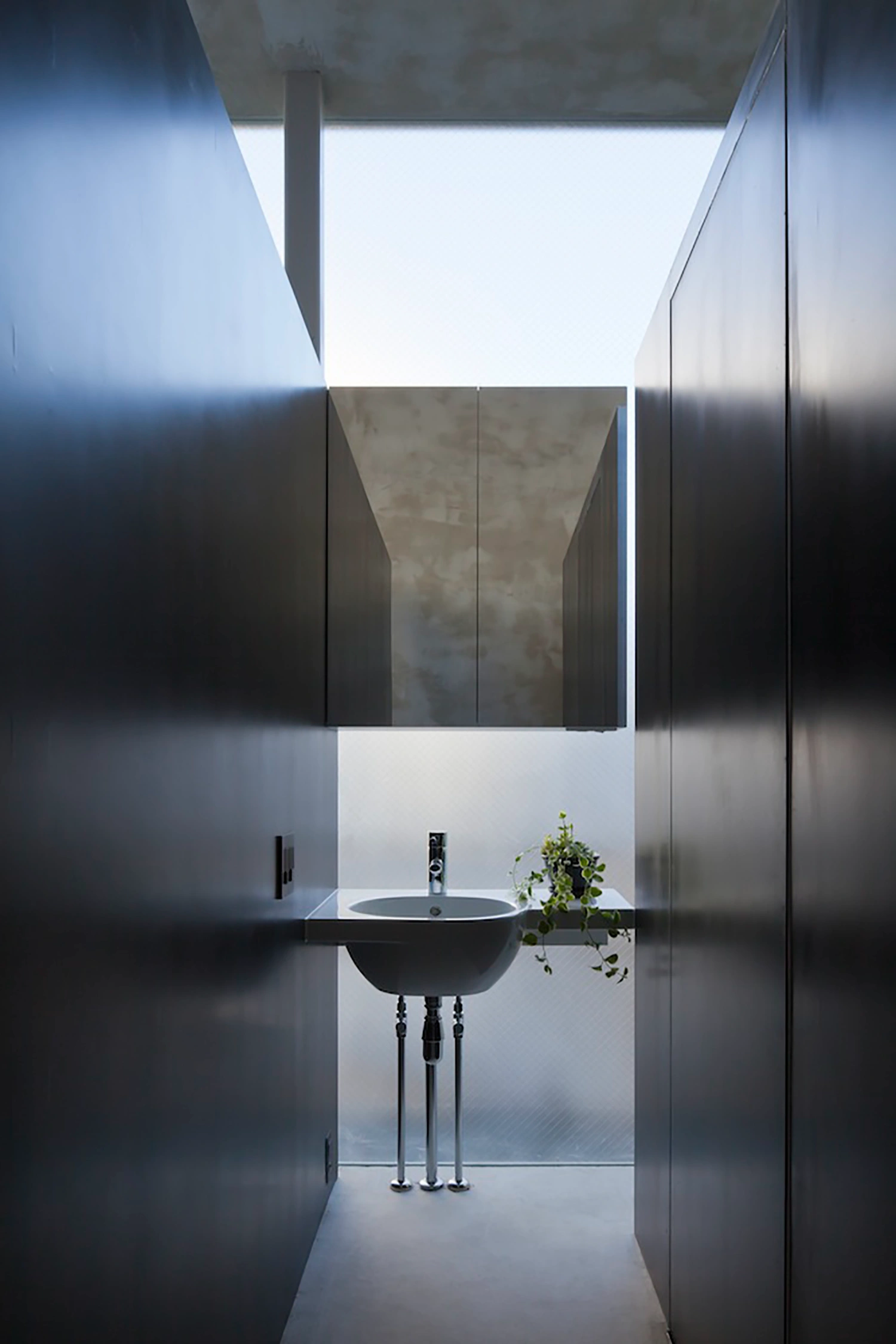 Tunnel House by Makiko Tsukada Architects — A view from within the tunnel threshold looking back toward the street reveals the project's core spatial strategy.