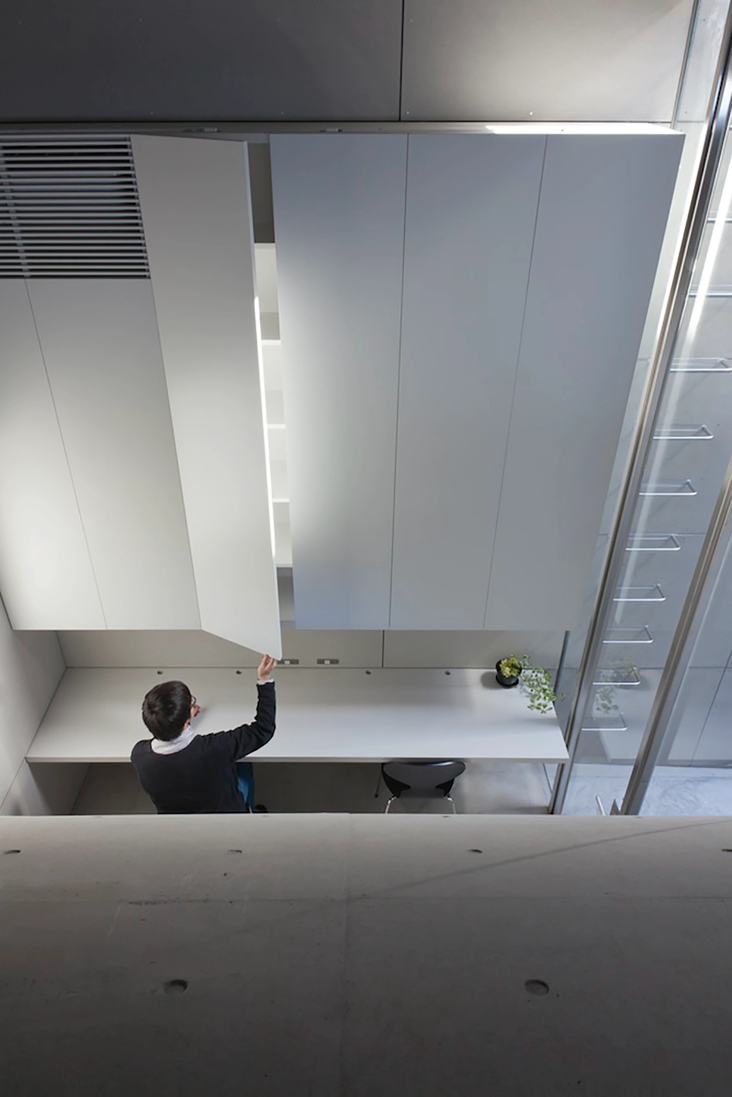 Tunnel House by Makiko Tsukada Architects — Overhead view into the Tunnel House's curved void, revealing the luminous quarter-cylinder passage carved through the dwelling's street-facing elevation.