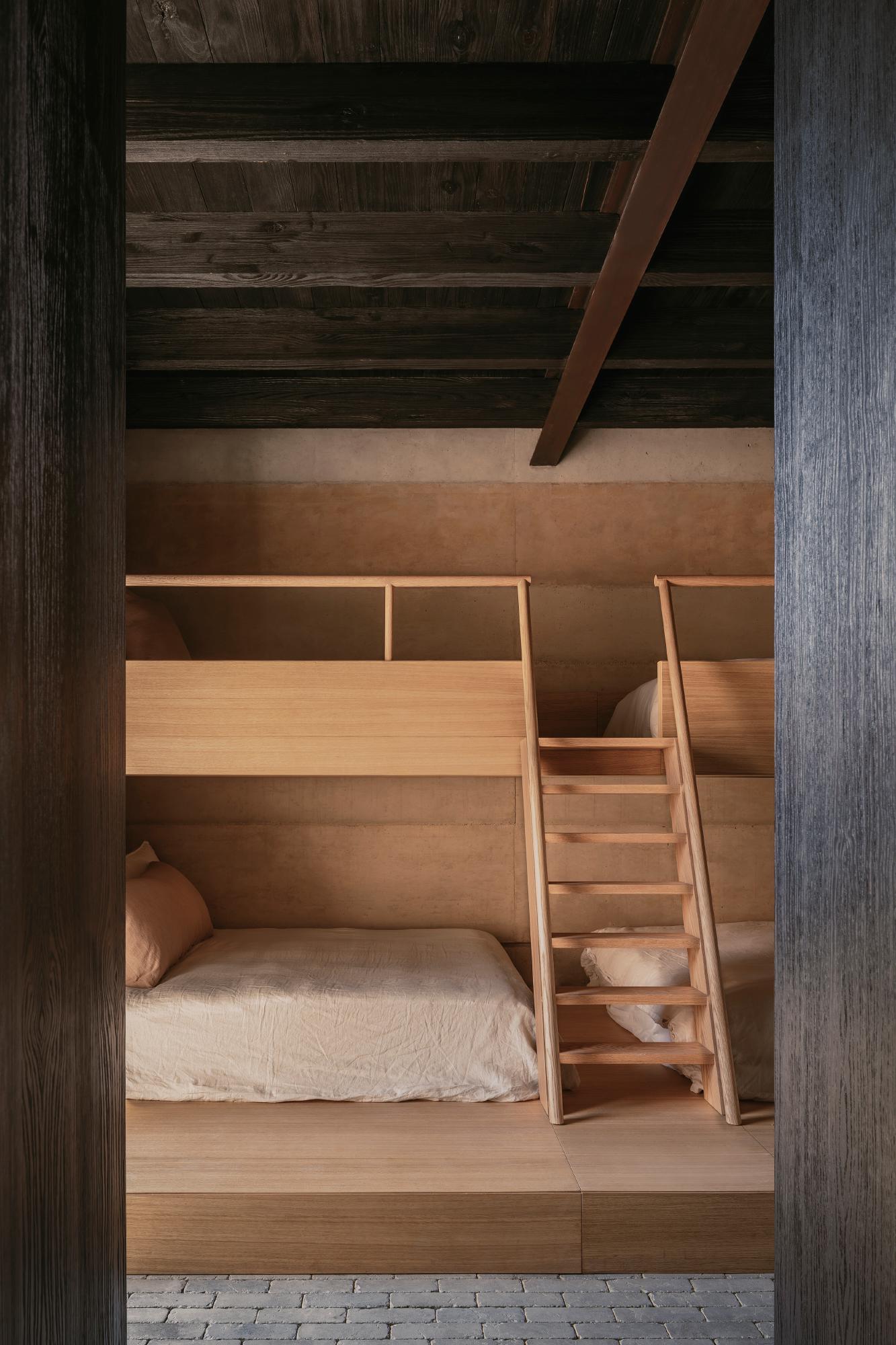 Casa el Espino by Soler Orozco Arquitectos — A bedroom chamber constructed entirely from light oak, featuring stacked bunk beds integrated into the wooden framework.