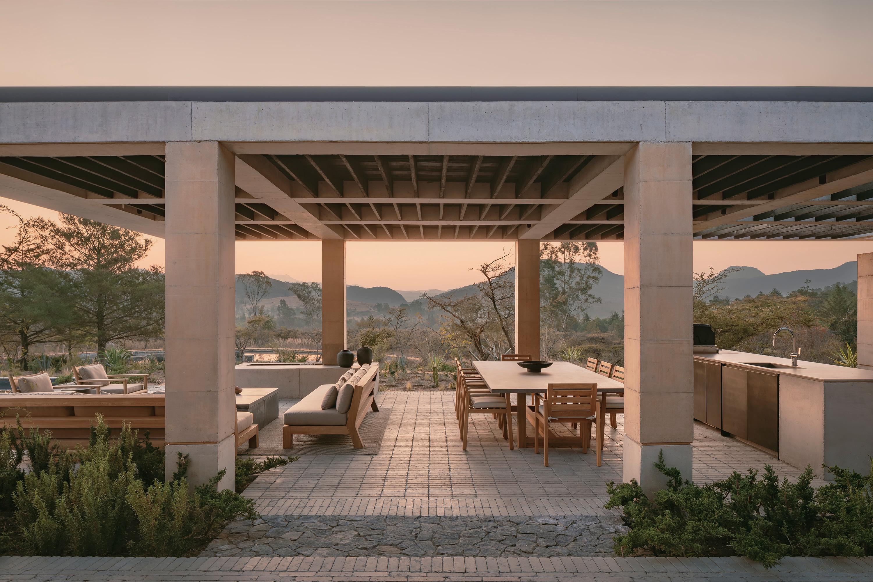 Casa el Espino by Soler Orozco Arquitectos — A covered terrace structured by massive concrete columns frames mountainous landscape views across Valle de Bravo.