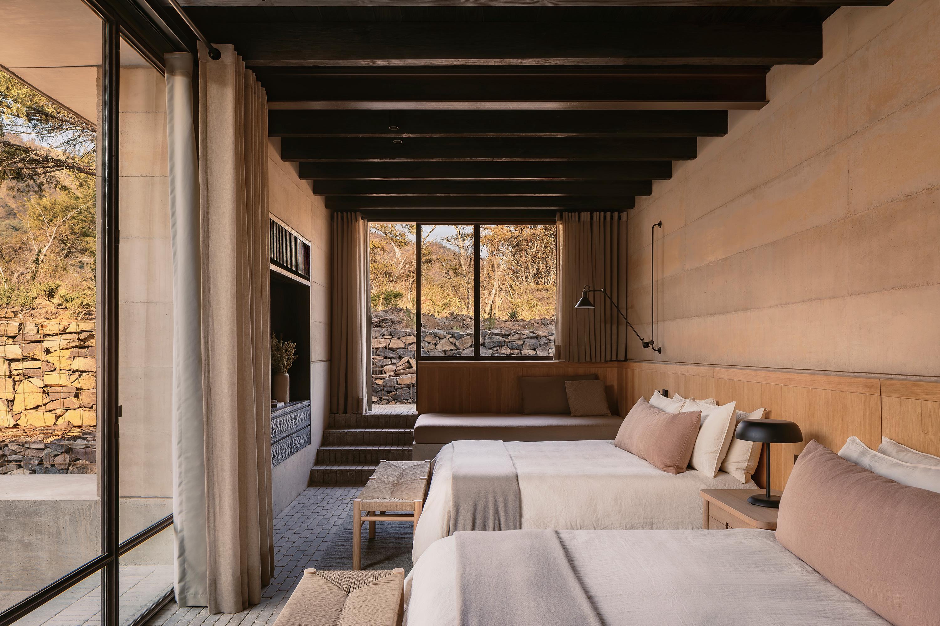 Casa el Espino by Soler Orozco Arquitectos — A double bedroom interior viewed lengthwise, revealing the deliberate spatial and material strategy of Casa el Espino.