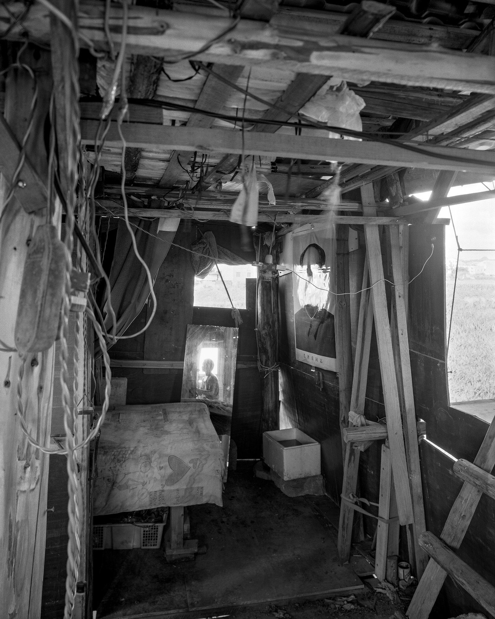 The Internal Crusade by Zexuan Zeng — Interior of an abandoned vehicle or mobile structure, photographed in black and white.