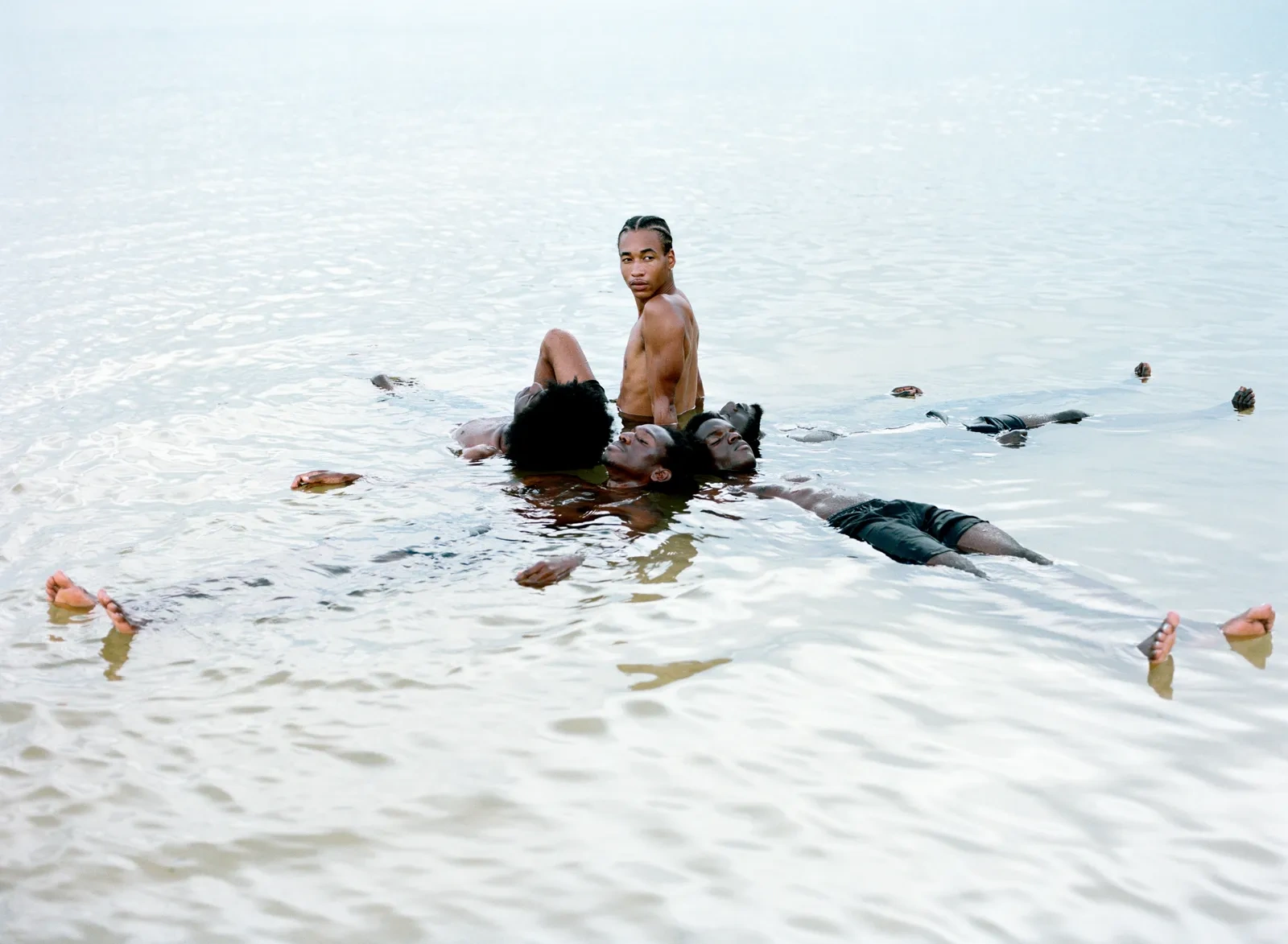 Florida Boys by Josh Aronson — Five figures occupy shallow ocean water in a wide-angle composition that distributes bodies across the frame at varying depths.