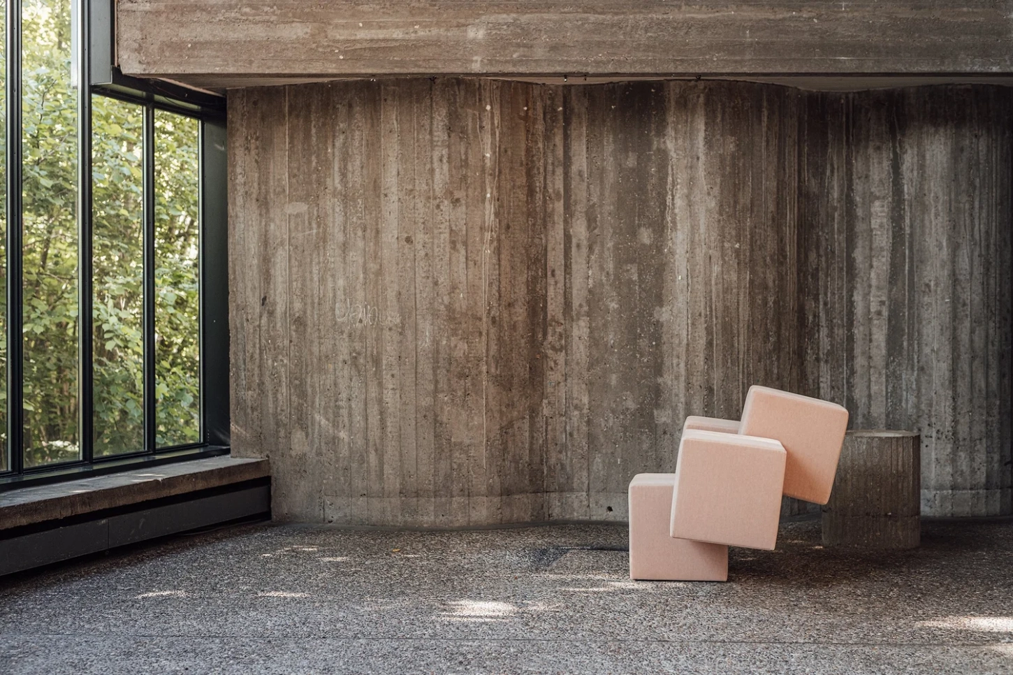 Cubist Chair by ÆTHER/MASS — Three upholstered cubic chairs in terracotta and cream occupy an industrial interior, arranged in loose triangular formation on aggregate concrete flooring.