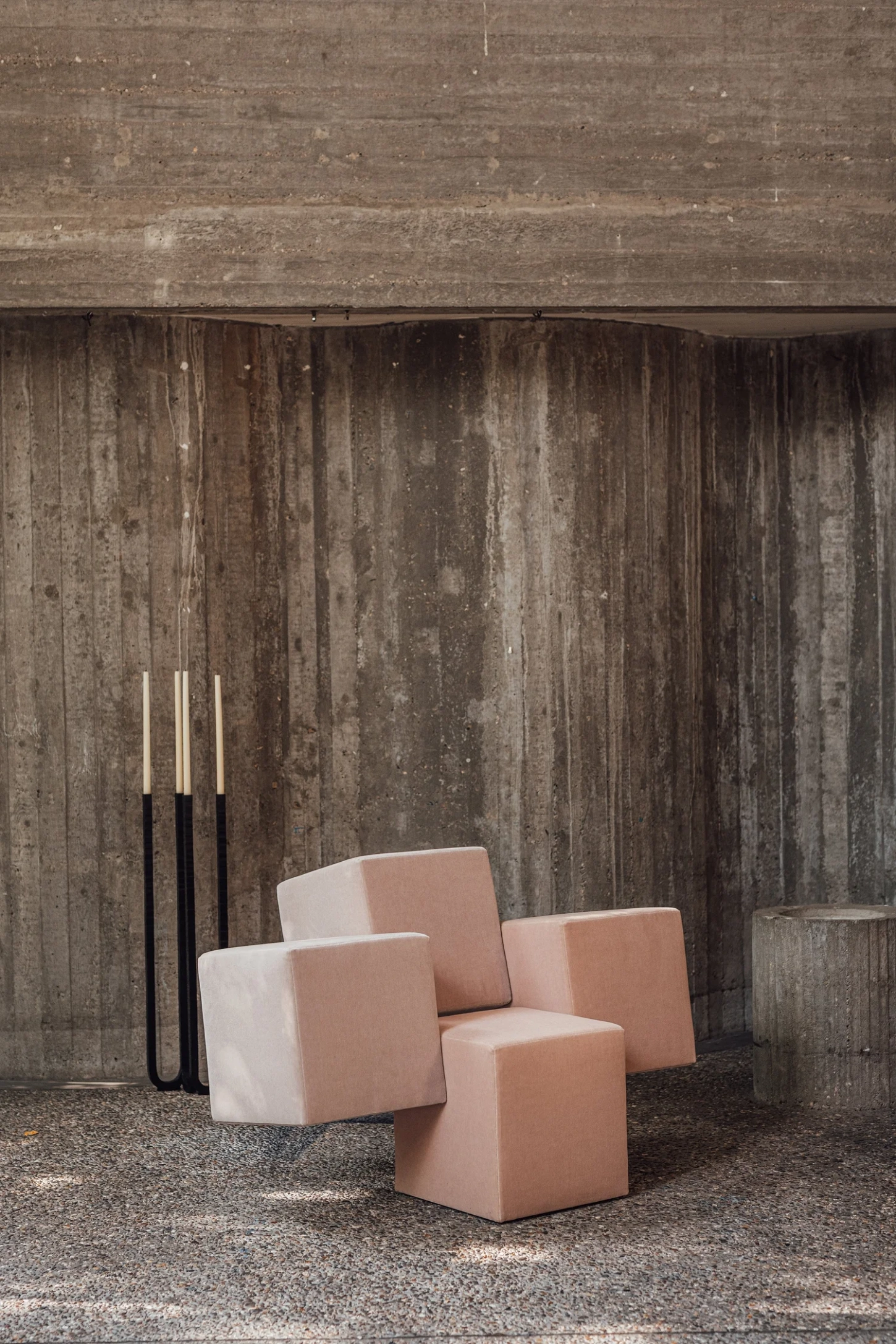 Cubist Chair by ÆTHER/MASS — Three upholstered cubic chairs in terracotta and cream occupy a gravel floor, arranged without conventional seating logic.