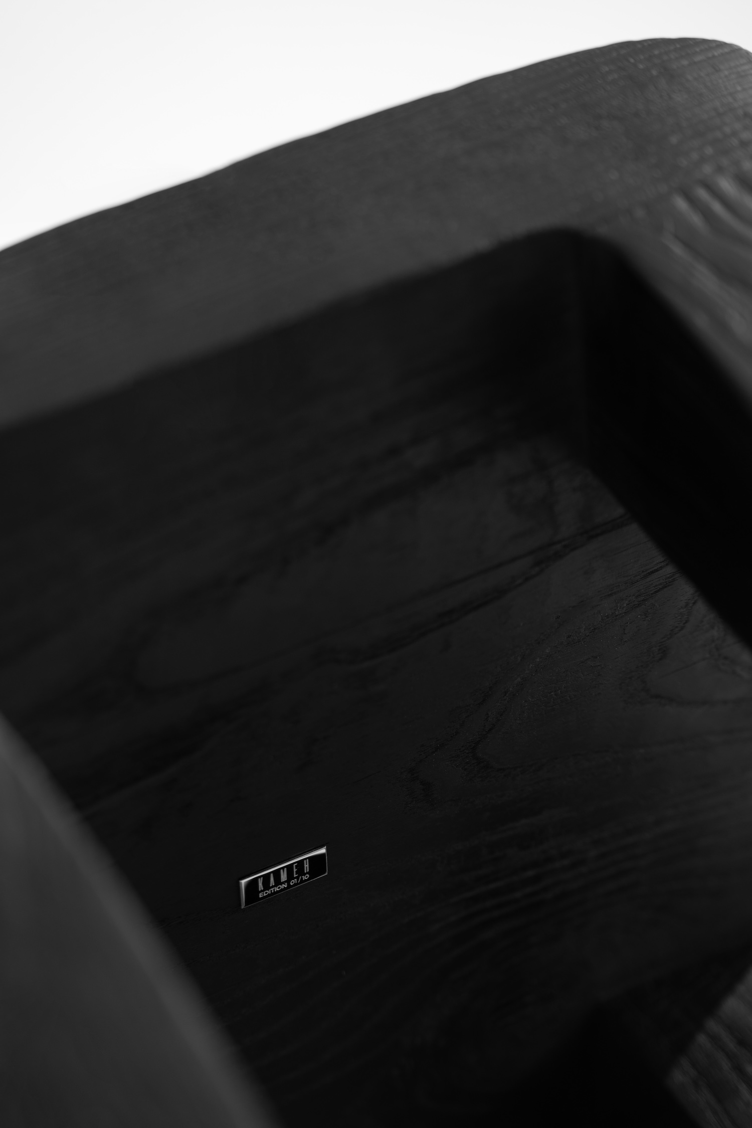 KAMEH 0.5 Collection by KAMEH — A charred timber chair from the KAMEH 0.5 collection shot from above, revealing the sculptural geometry of its seat and backrest.