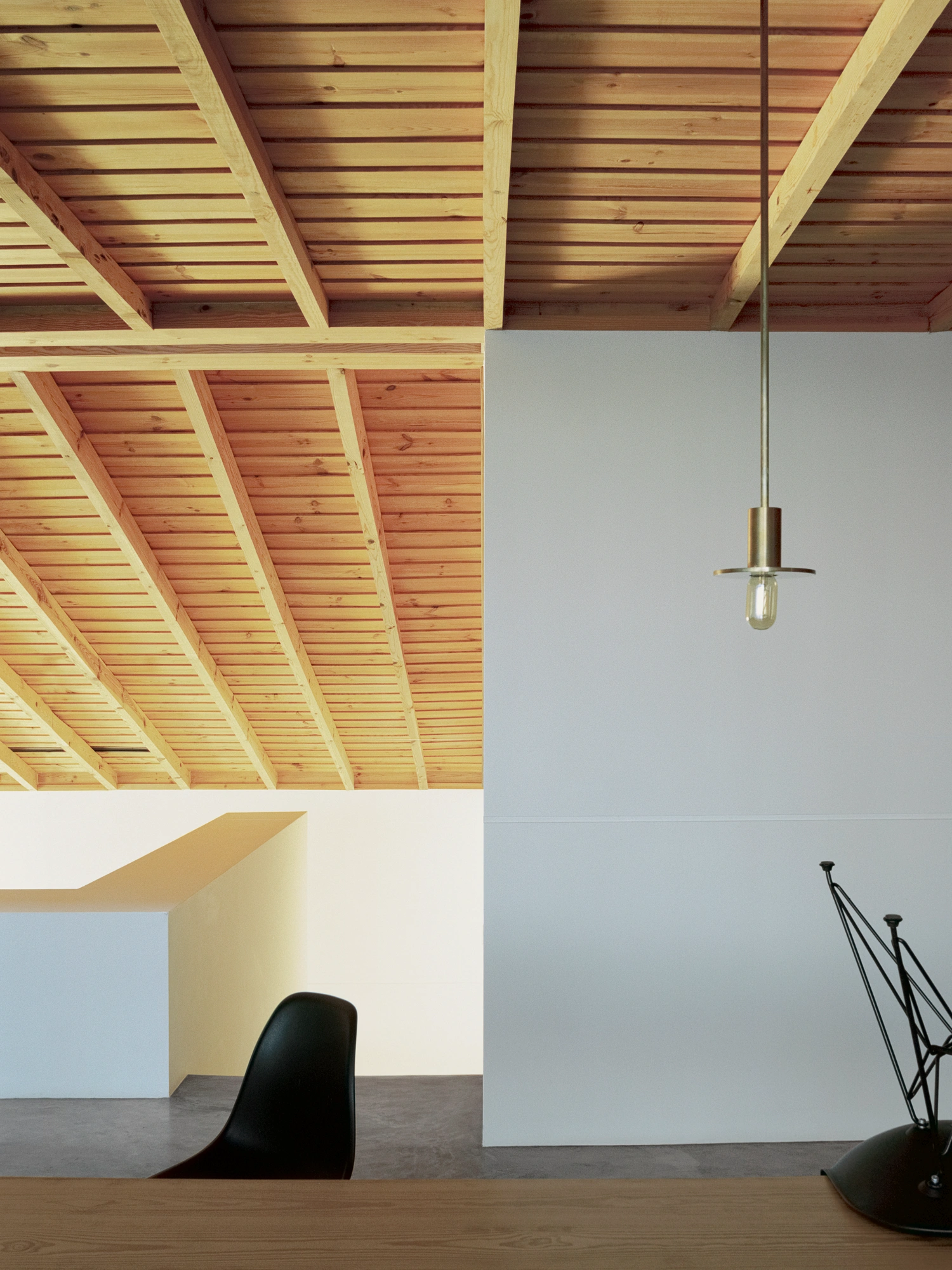 Herdade da Cardeira Winery by EMBAIXADA by EMBAIXADA arquitectura — Interior workspace beneath exposed timber rafter ceiling with regularly spaced joists in pine or similar light wood.