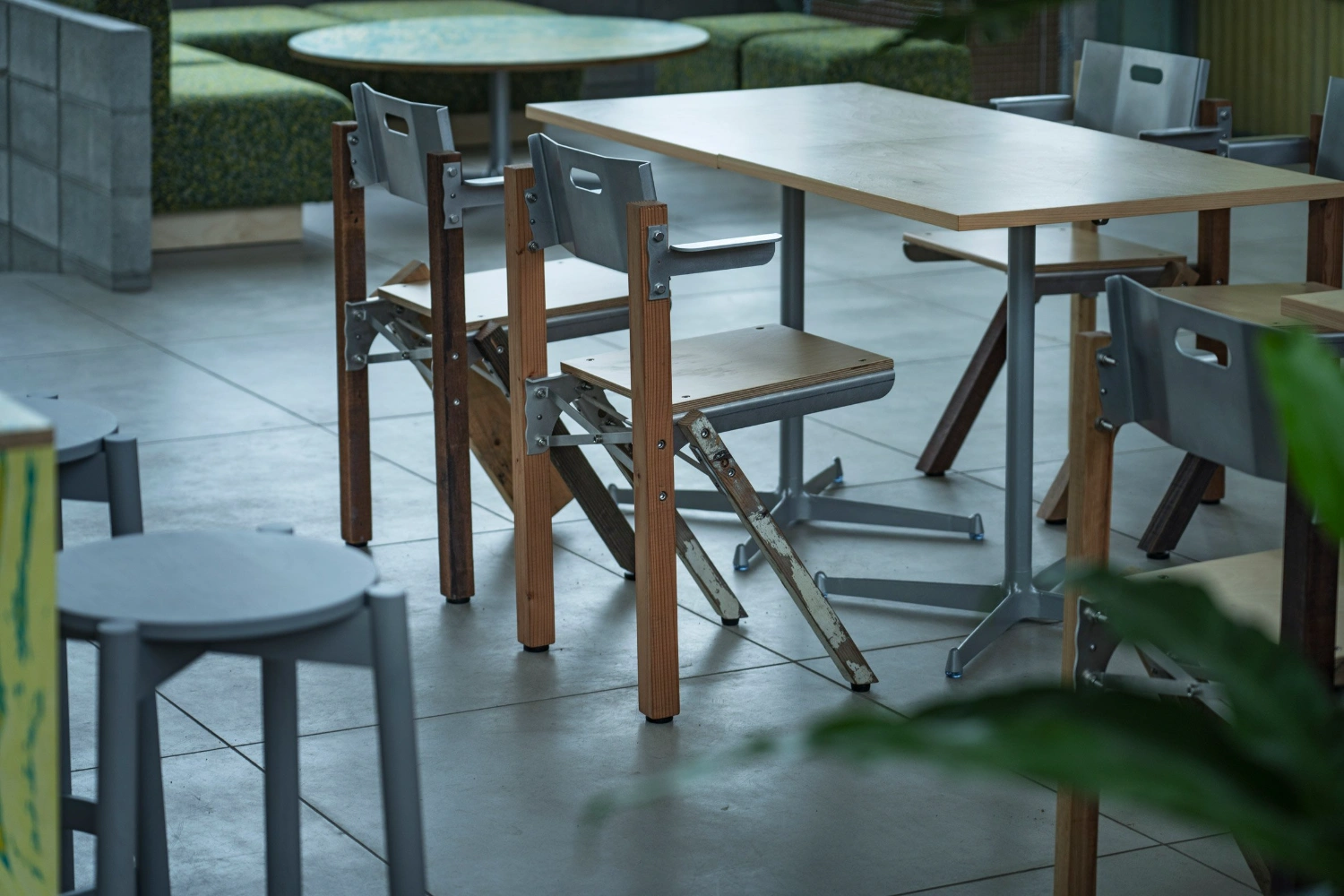 Teshima Factory Cafe by Schemata Architects — The cafeteria interior reveals a post-and-beam structural system with timber columns and steel cross-bracing, their industrial patina preserved from the...