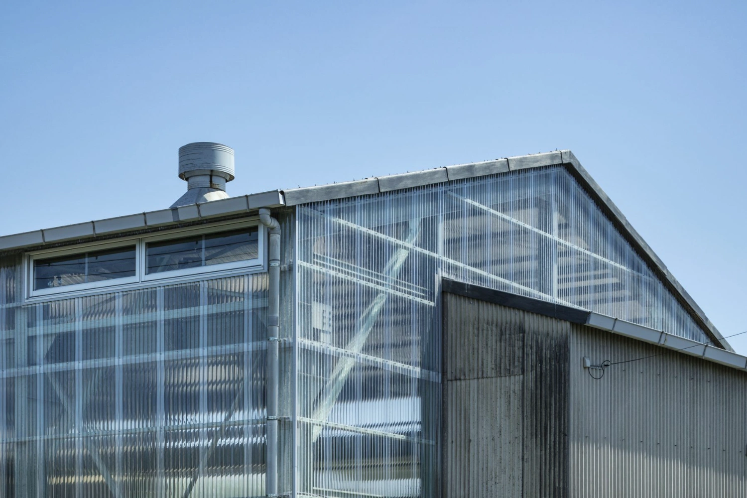 Teshima Factory Cafe by Schemata Architects — The cafeteria facade of Teshima Factory Cafe presents a transparent threshold between interior and landscape.