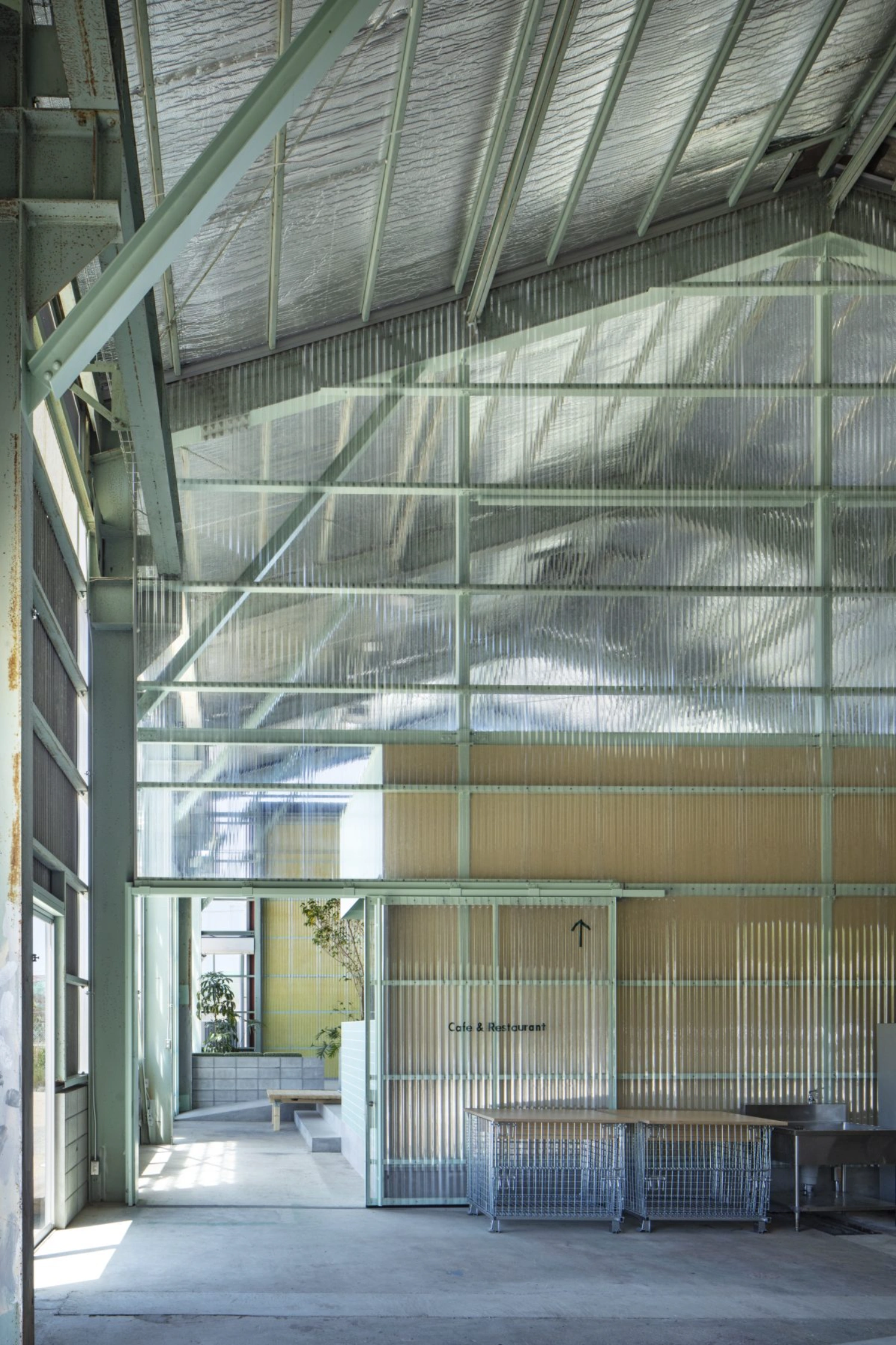 Teshima Factory Cafe by Schemata Architects — The interior forecourt of the Teshima Factory Cafe demonstrates the calibrated transition between industrial retention and new insertion.