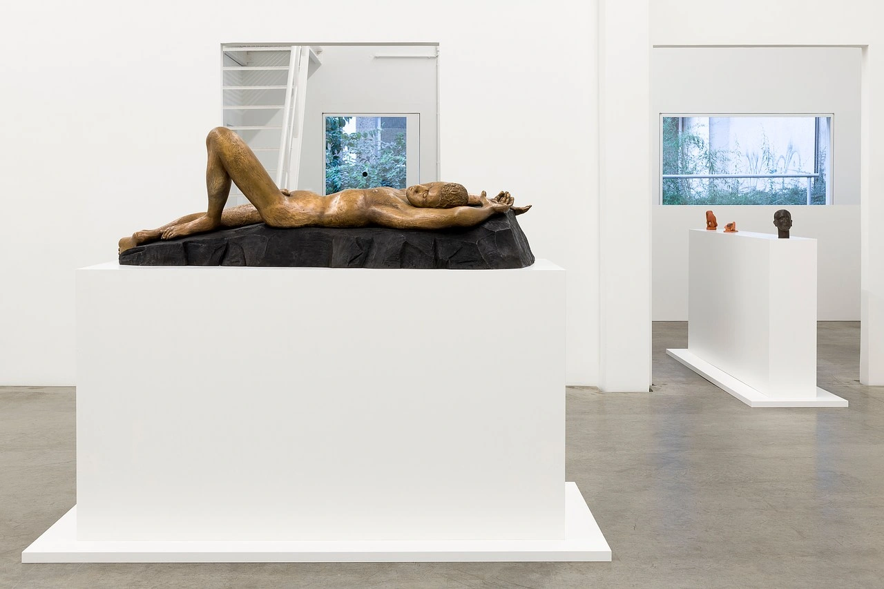 La scorza by Louis Fratino at Galerie Neu — A bronze reclining male figure occupies a black stone plinth positioned on a white gallery pedestal.