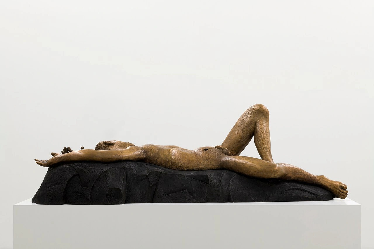 La scorza by Louis Fratino at Galerie Neu — A bronze figure reclines across a black carved-wood base, one leg extended in languid repose while the other bends upward.