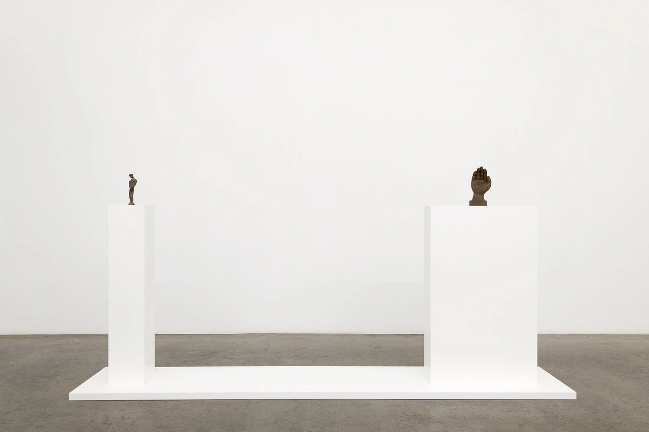 La scorza by Louis Fratino at Galerie Neu — Two bronze figurative sculptures occupy a minimalist white platform set against a neutral gallery wall.