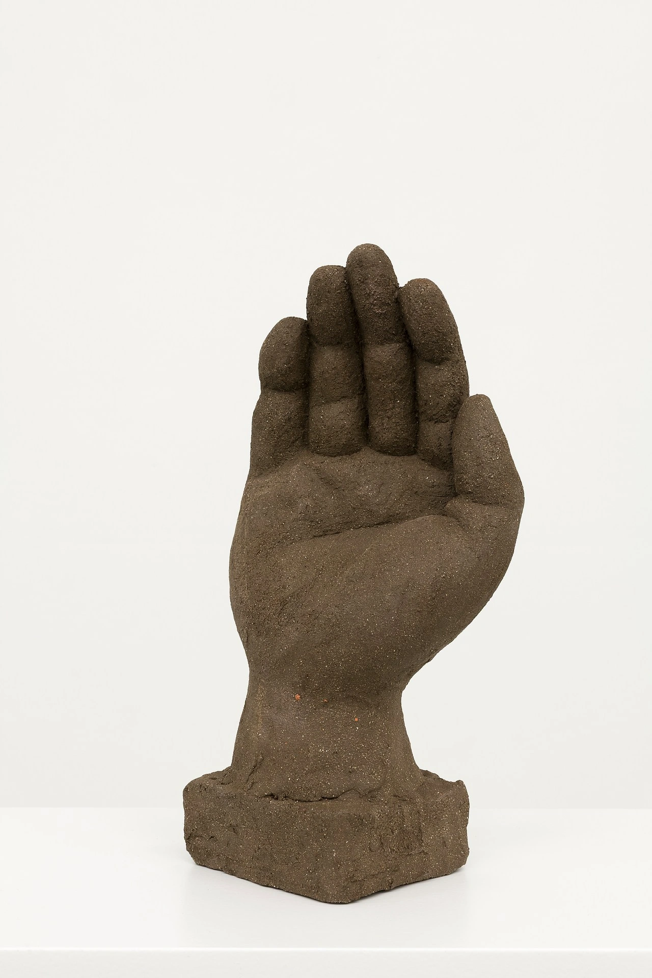 La scorza by Louis Fratino at Galerie Neu — A cast-bronze sculptural hand extends upward in an open, receptive gesture, its surface weathered to a warm gray-brown patina.