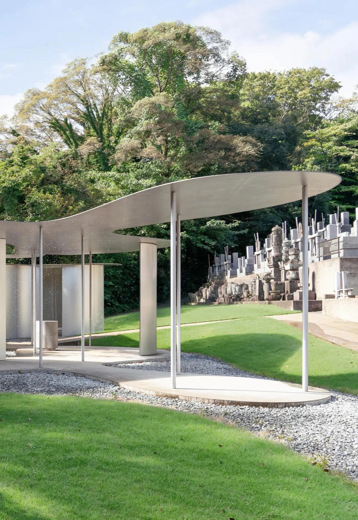 Sonei-ji Cemetery Pavilion (Muyujurin) by SANAA — The Sonei-ji Cemetery Pavilion frames a manicured lawn and distant stone monuments through its transparent structural system.