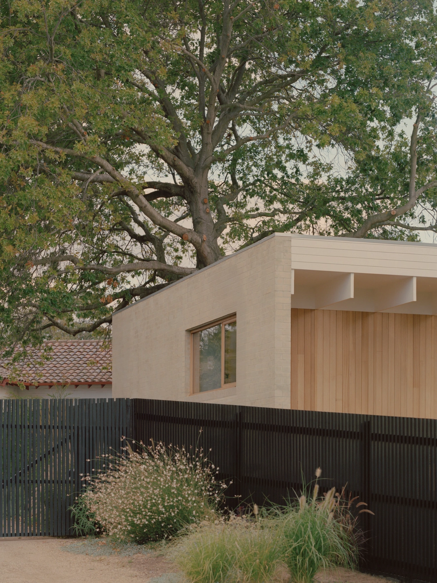 Mount Martha House by Victoria Merrett Architects — The Mount Martha residence presents itself as a restrained geometric form, its cream render facade punctuated by timber-framed glazing that frames the...