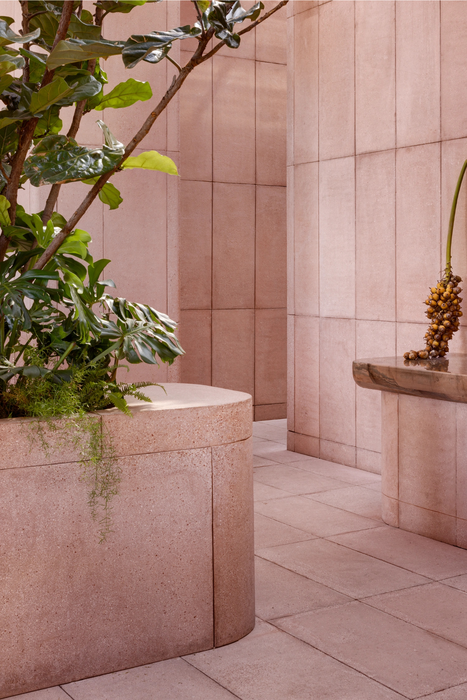 Rubra Restaurant by Ignacio Urquiza + Ana Paula de Alba — A terracotta-toned courtyard space defined by mauve-pink ceramic tiles in uniform grid pattern, covering walls from floor to ceiling with pronounced...