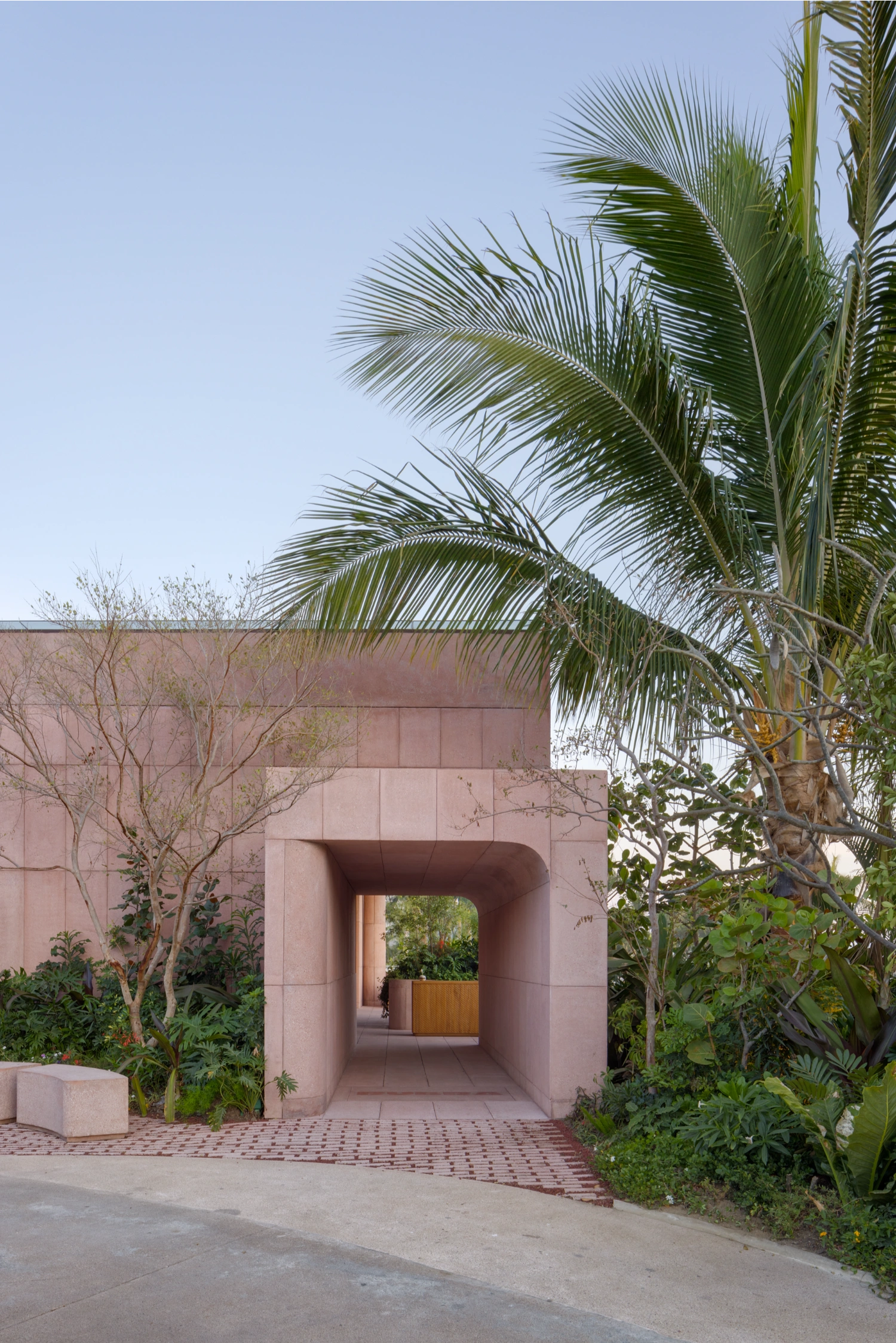 Rubra Restaurant by Ignacio Urquiza + Ana Paula de Alba — The entrance passage frames a compressed threshold experience in mauve-pink ceramic tile, its uniform grid pattern and vertical grout lines establishing...