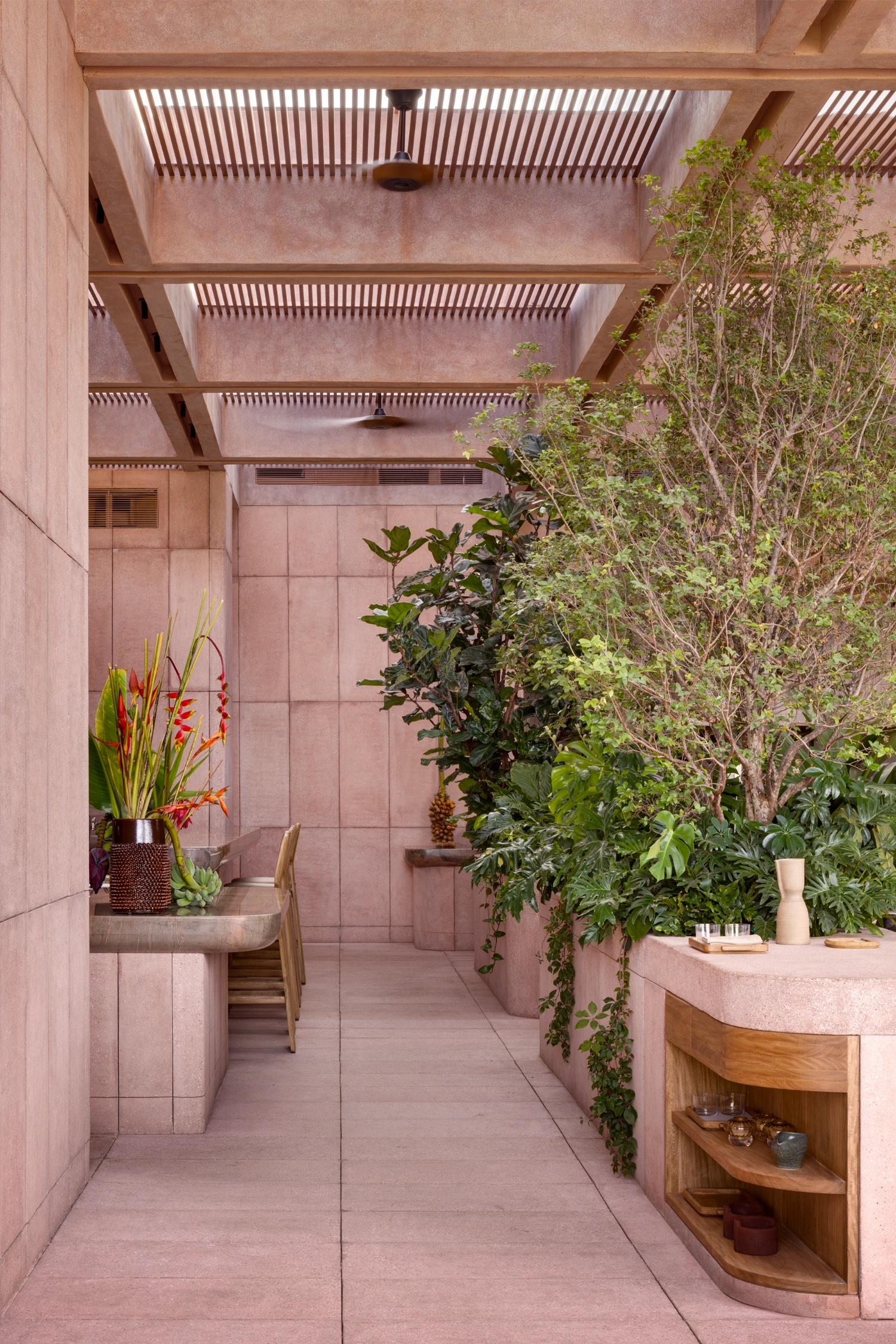 Rubra Restaurant by Ignacio Urquiza + Ana Paula de Alba — A narrow interior corridor lined with mauve-pink ceramic tiles in uniform grid pattern extends toward a lush vertical garden.