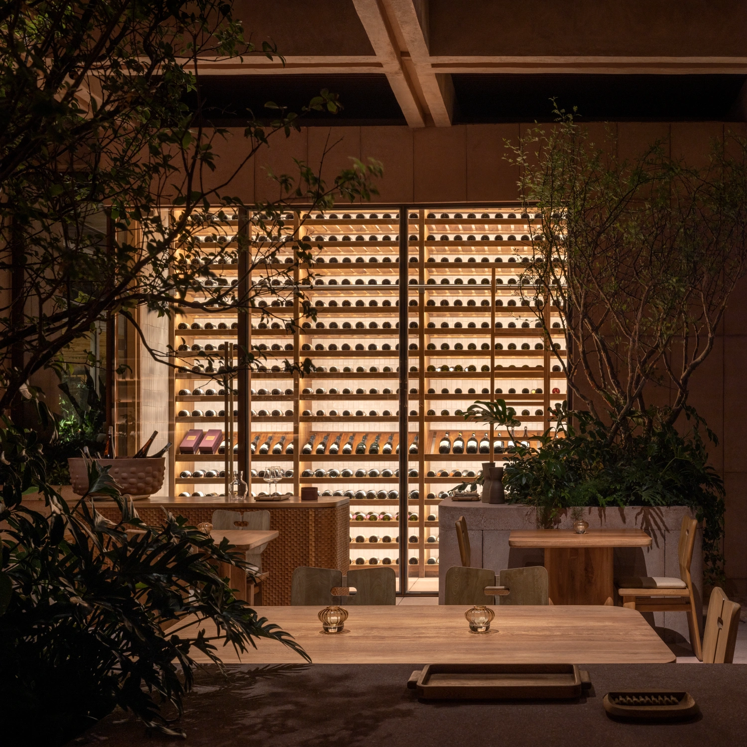 Rubra Restaurant by Ignacio Urquiza + Ana Paula de Alba — A dining interior framed by a monumental ceramic tile wall—hundreds of terracotta vessels arranged in a gridded modular display that spans floor to ceiling.