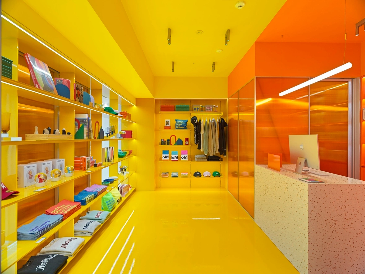 MoMA Bookstore at Hyundai Card in Seoul — The MoMA Bookstore interior showcases a volumetric retail strategy defined by continuous yellow-painted surfaces—ceiling, floor, and recessed shelving...