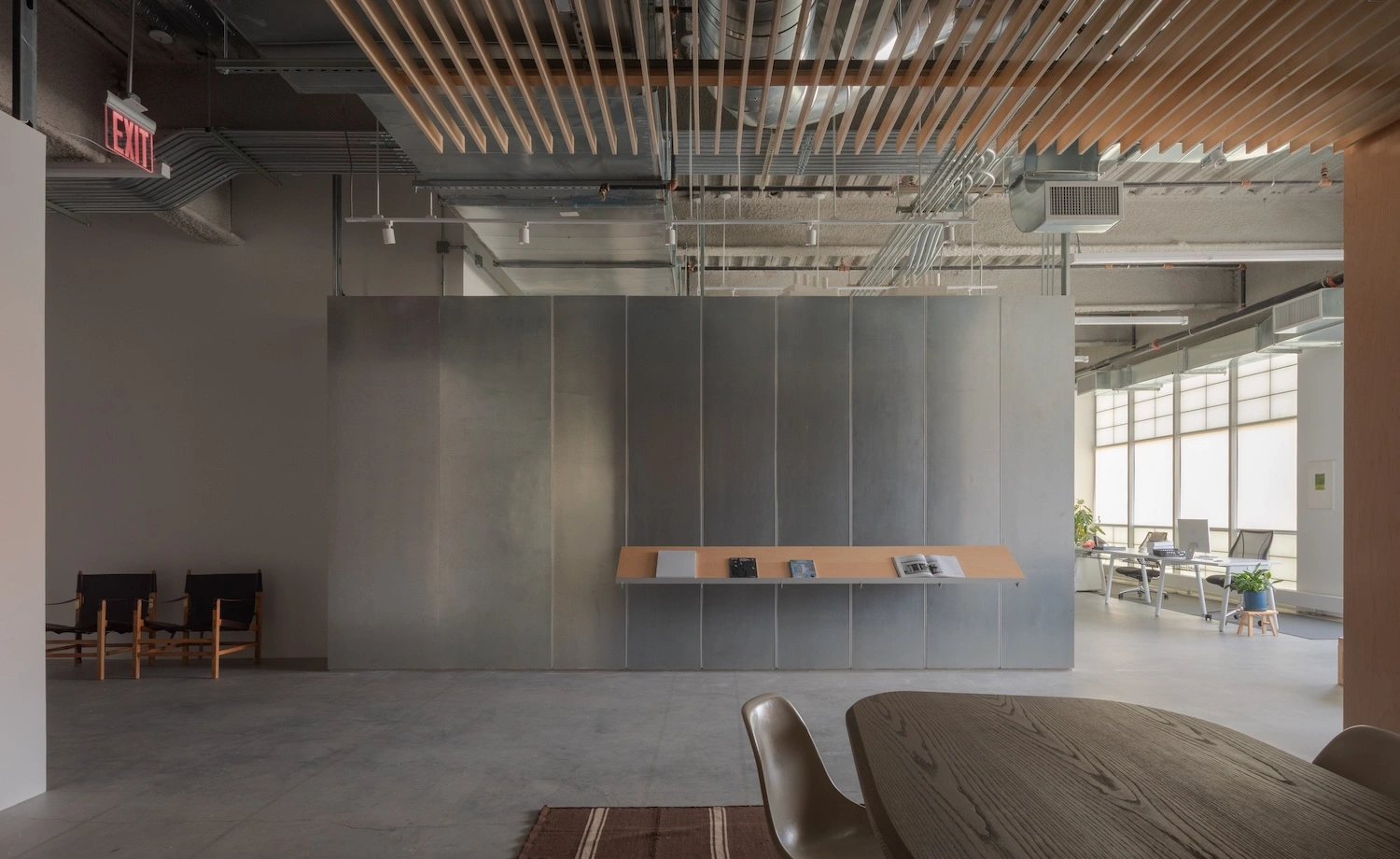 Glenn Ligon Artist’s Studio by Ravi Raj Architect — The studio's open floor plate demonstrates spatial organization through a monolithic steel-framed partition wall, its gridded panels rendered in matte grey...