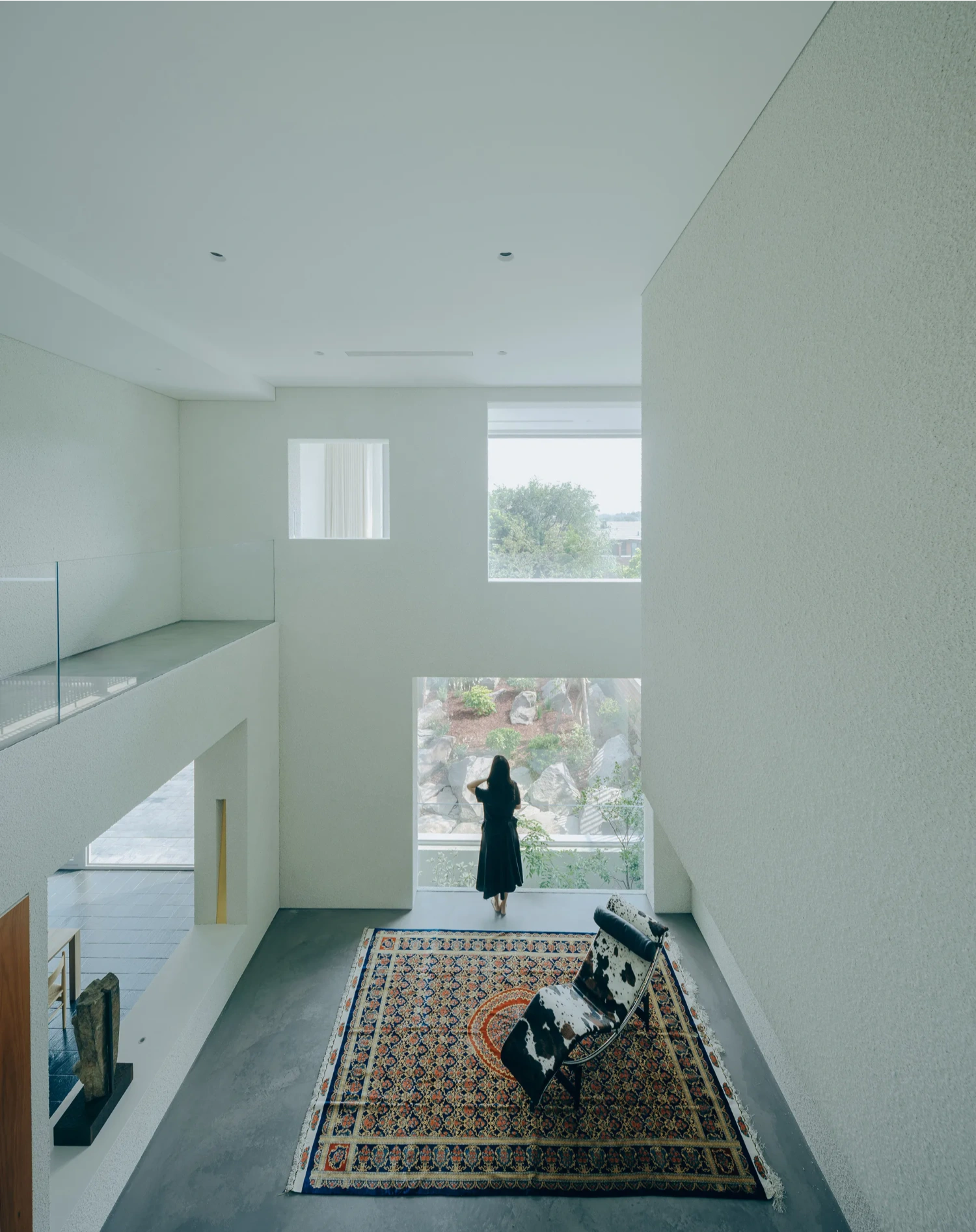 House J in Beijing by Atelier About Architecture — A double-height interior passage defined by rendered plaster walls in cream and sage tones.