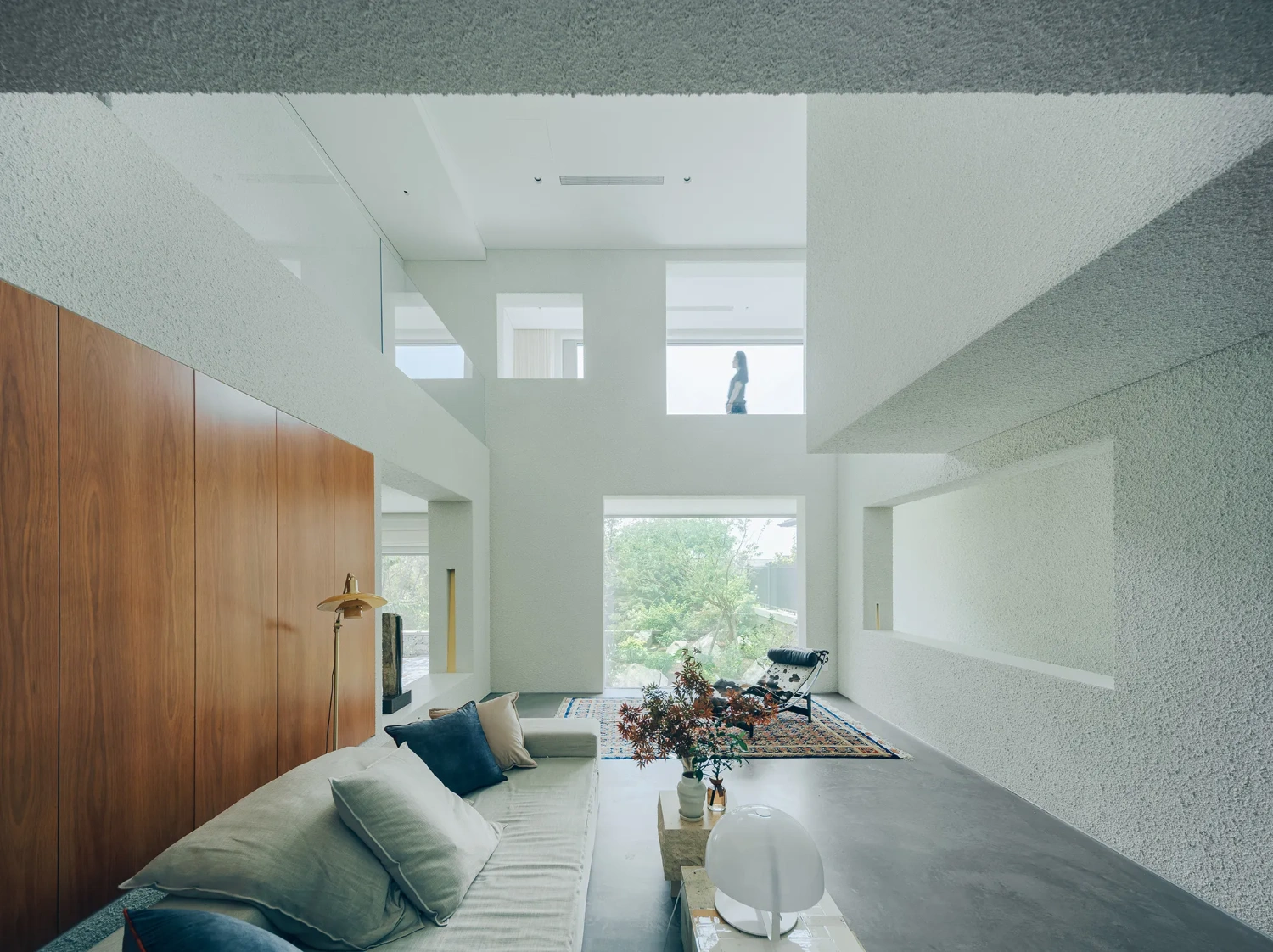 House J in Beijing by Atelier About Architecture — A double-height living space orchestrated around layered views and material contrasts.