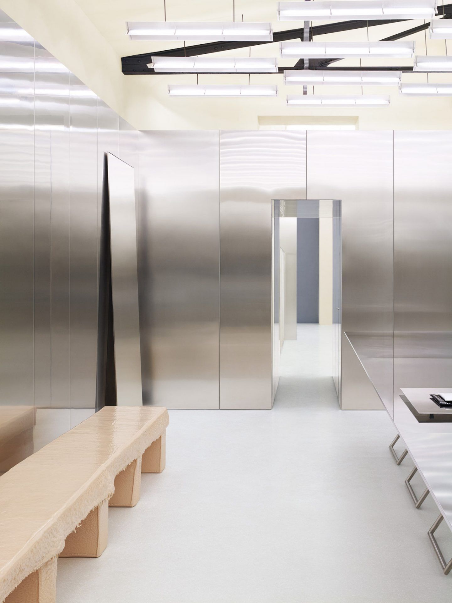 Acne Studios by Bubab Architects — The retail interior demonstrates spatial transparency through floor-to-ceiling glass and steel partitions that create distinct zones without visual obstruction.