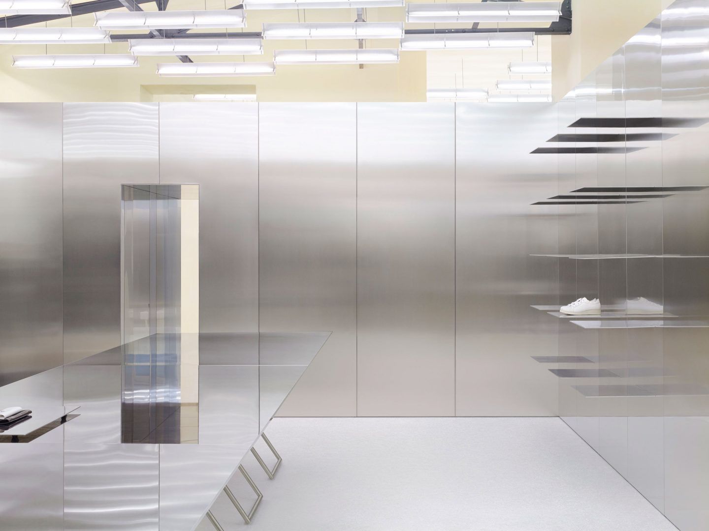 Acne Studios by Bubab Architects — A transparent retail environment viewed from the entrance threshold, defined by floor-to-ceiling glass partitions that subdivide the 260-square-meter space...
