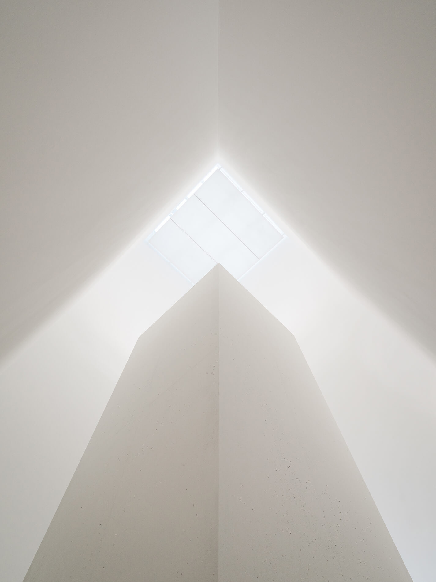 Museum of Modern Art in Warsaw by Thomas Phifer — Looking upward through the museum's interior void, the photograph captures stacked concrete floor plates with recessed edges that cast shadow lines across...